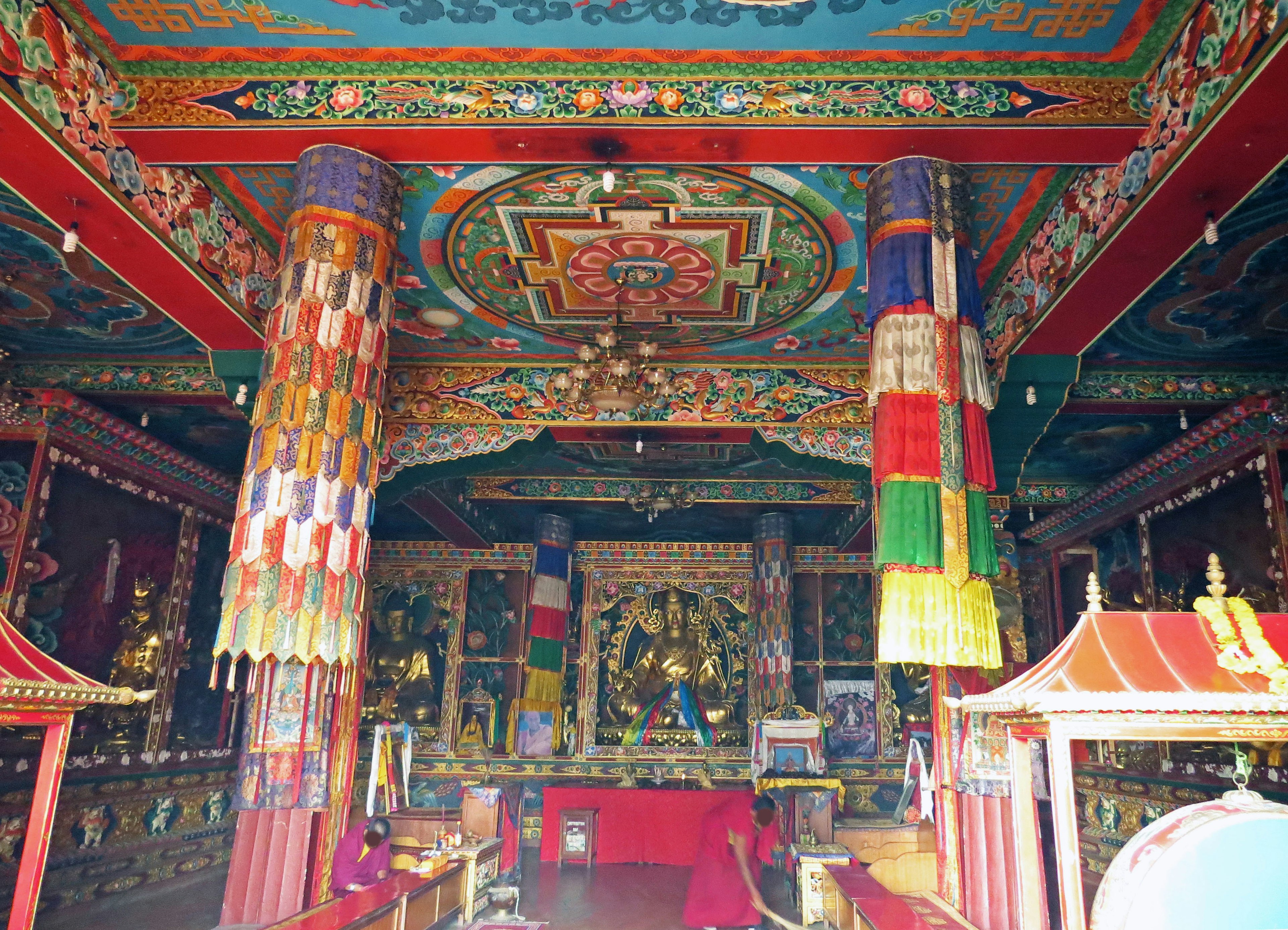 Intérieur d'un temple avec des piliers colorés et des décorations de plafond complexes