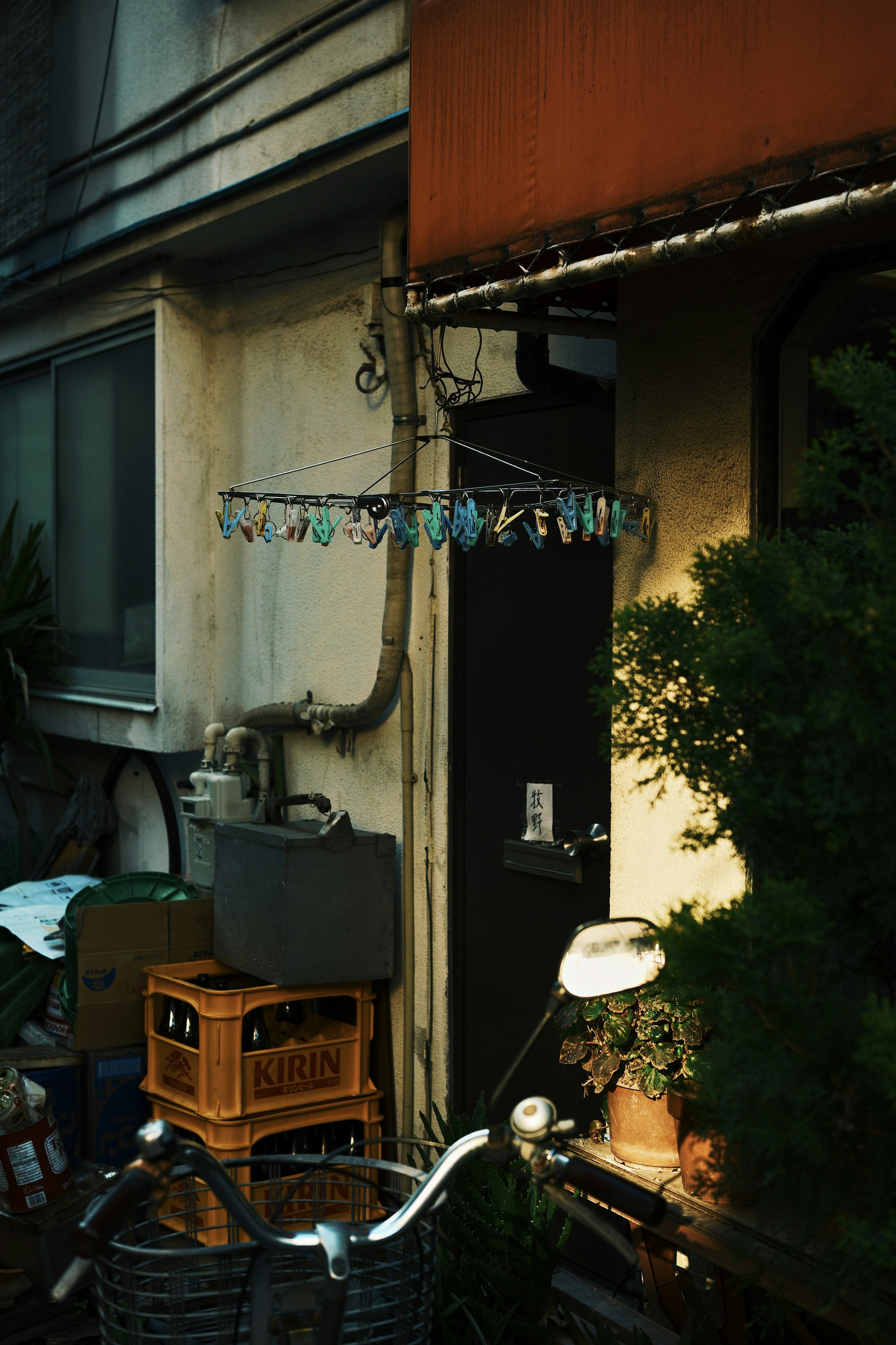 古い建物の入り口と自転車のある風景 植物と洗濯物が見える