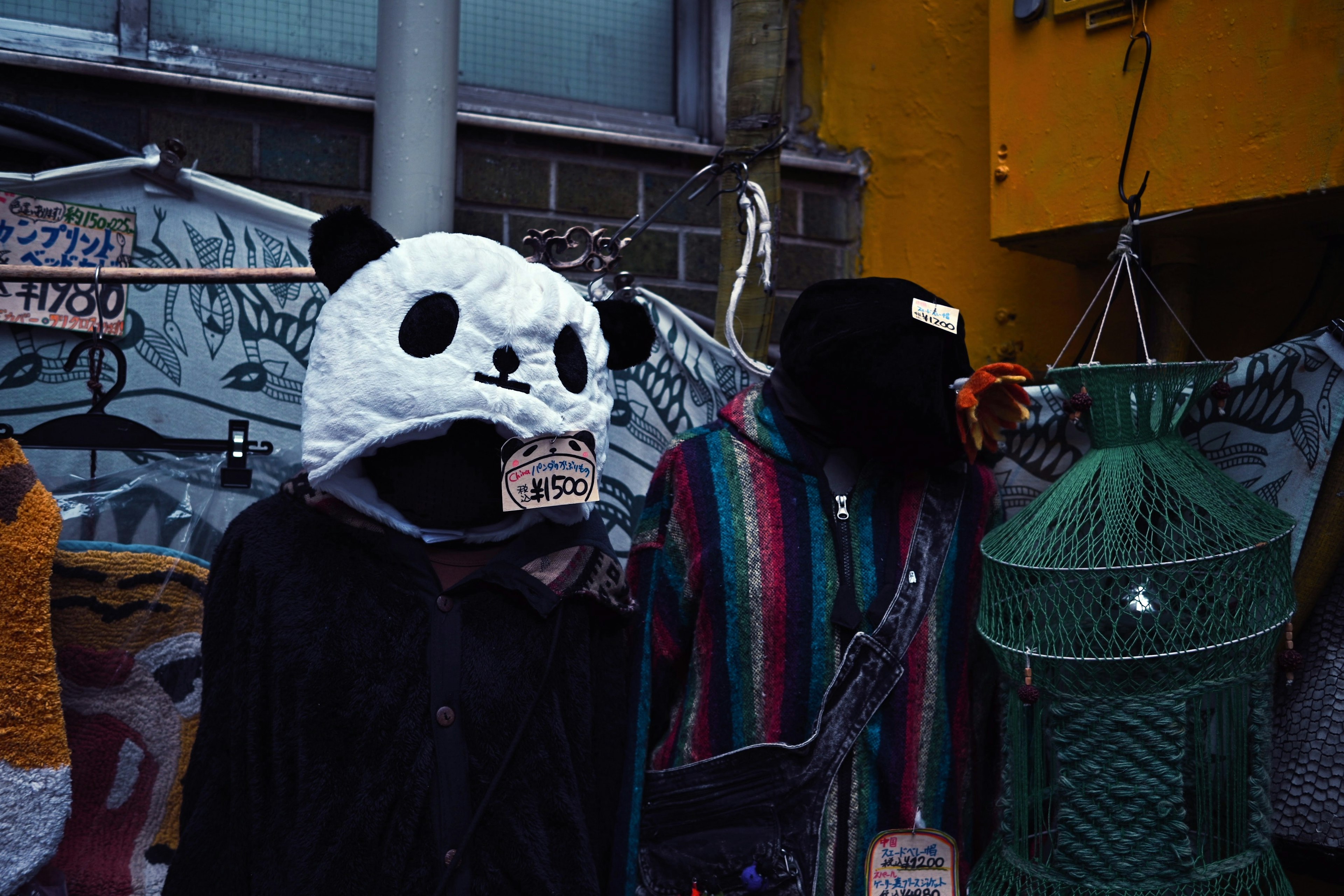 Un manichino con una testa di panda e un altro manichino in abiti colorati esposti all'aperto