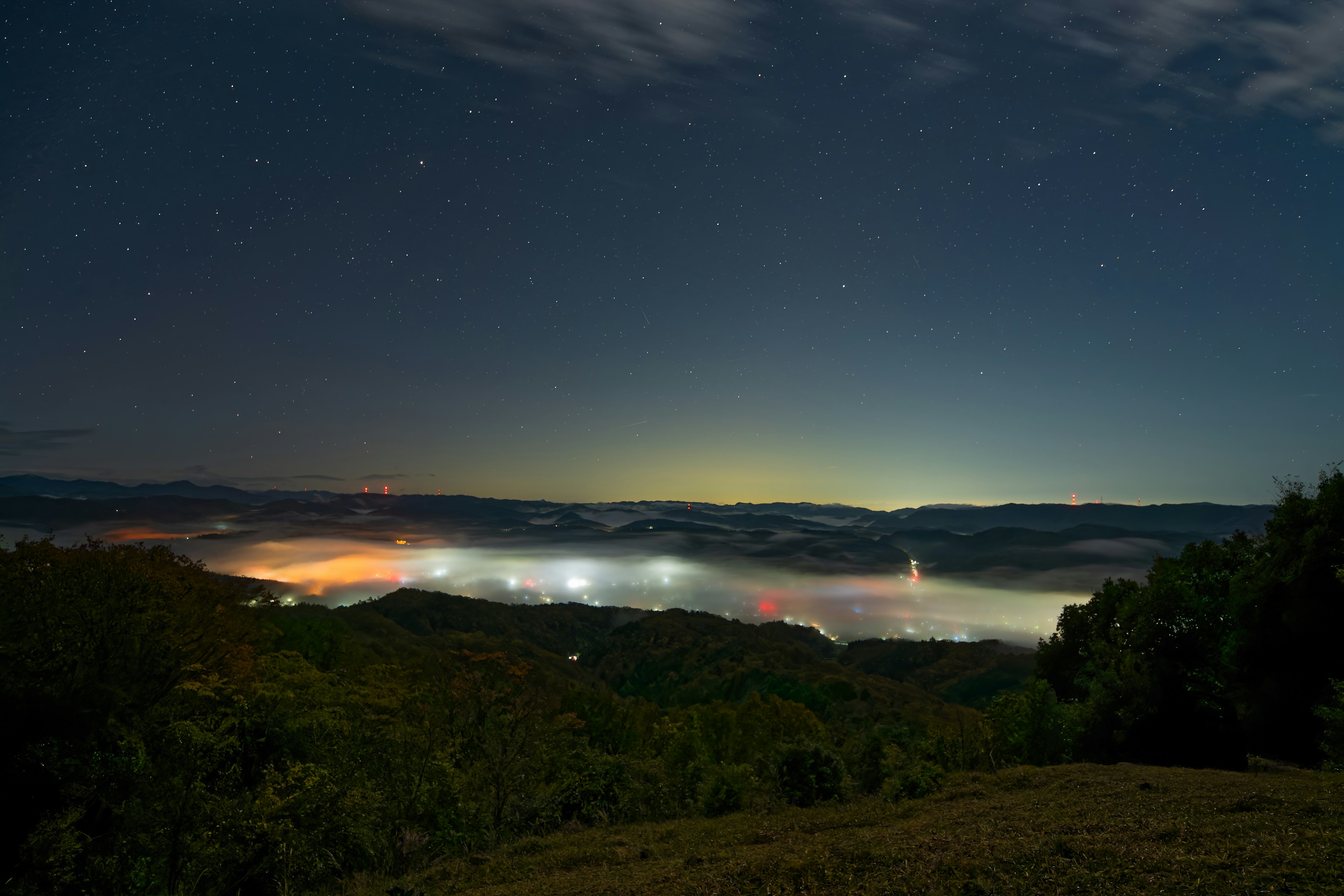 夜空に輝く星々と霧に包まれた谷の美しい風景