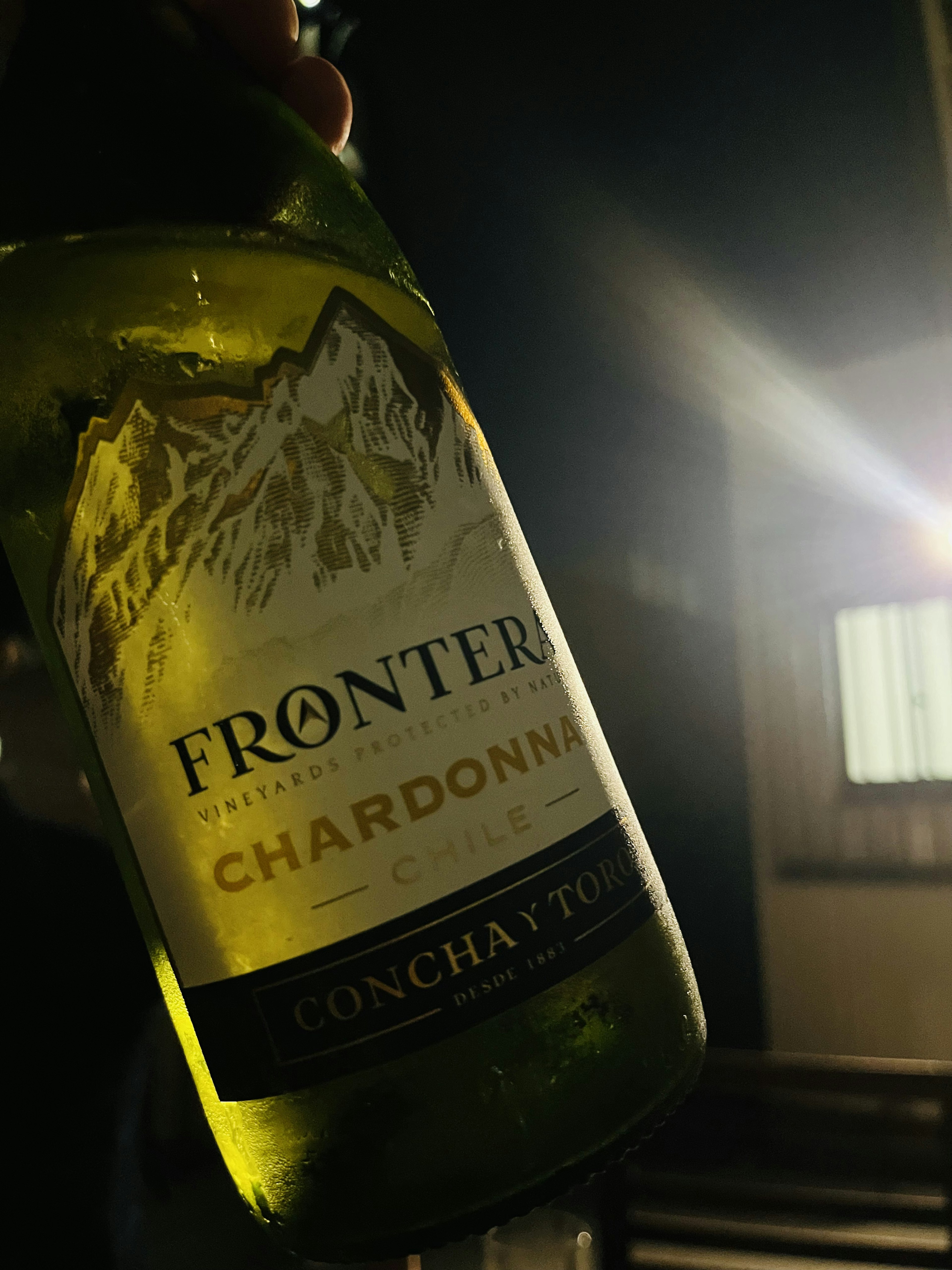 ขวด Chardonnay Frontera ที่ส่องสว่างในแสงสลัว