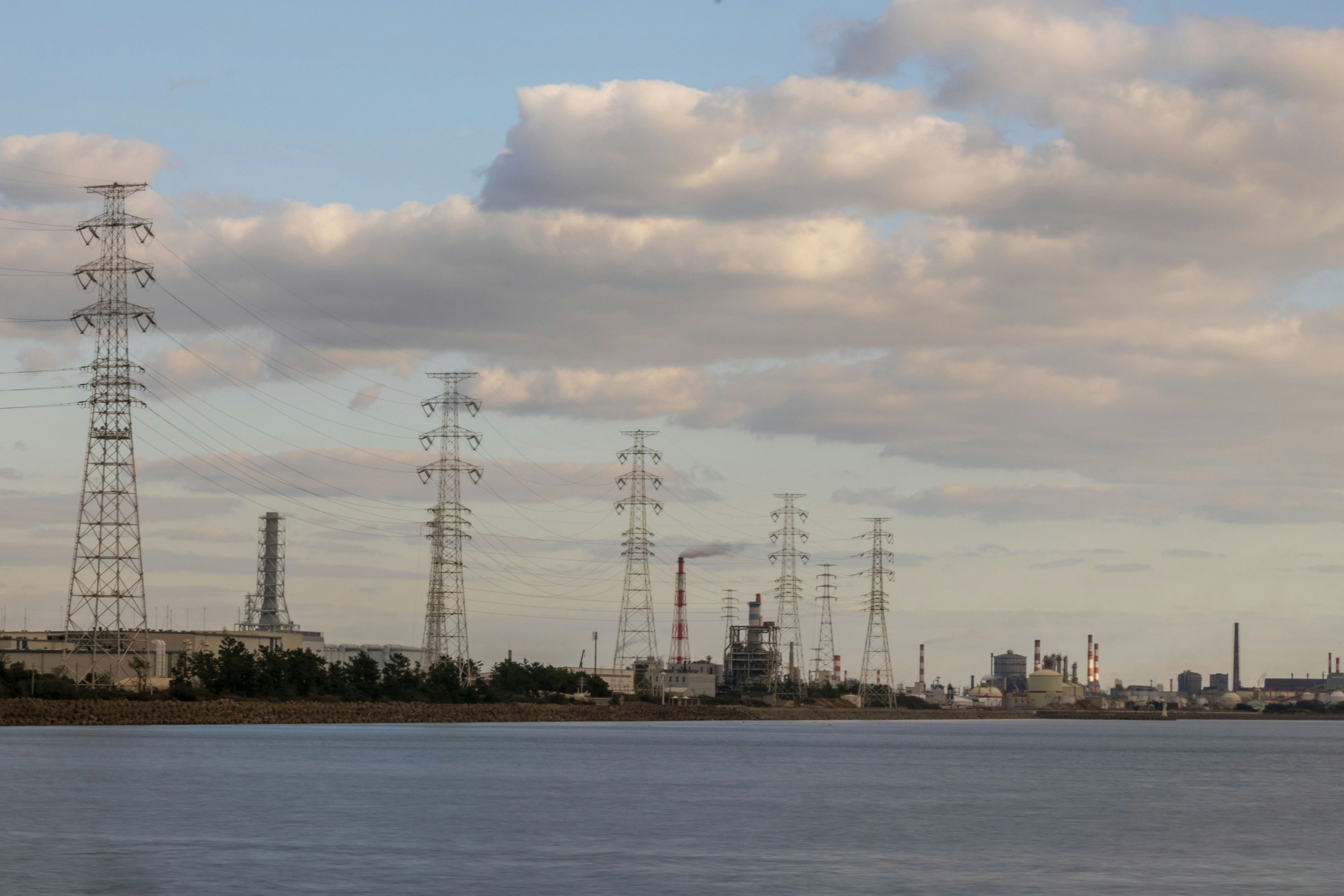 Coastal view featuring power lines and industrial buildings