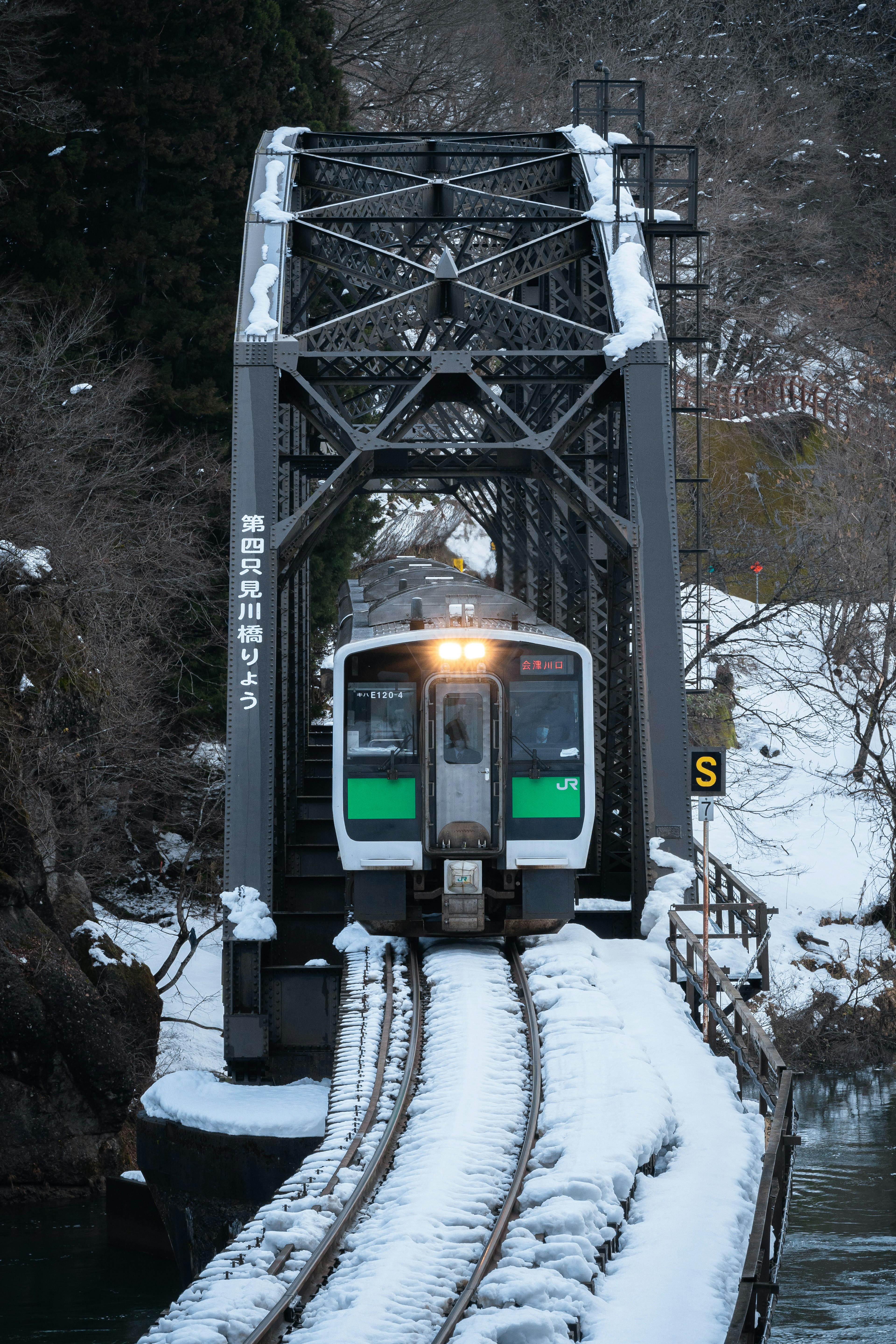 Treno che attraversa un ponte ferroviario coperto di neve