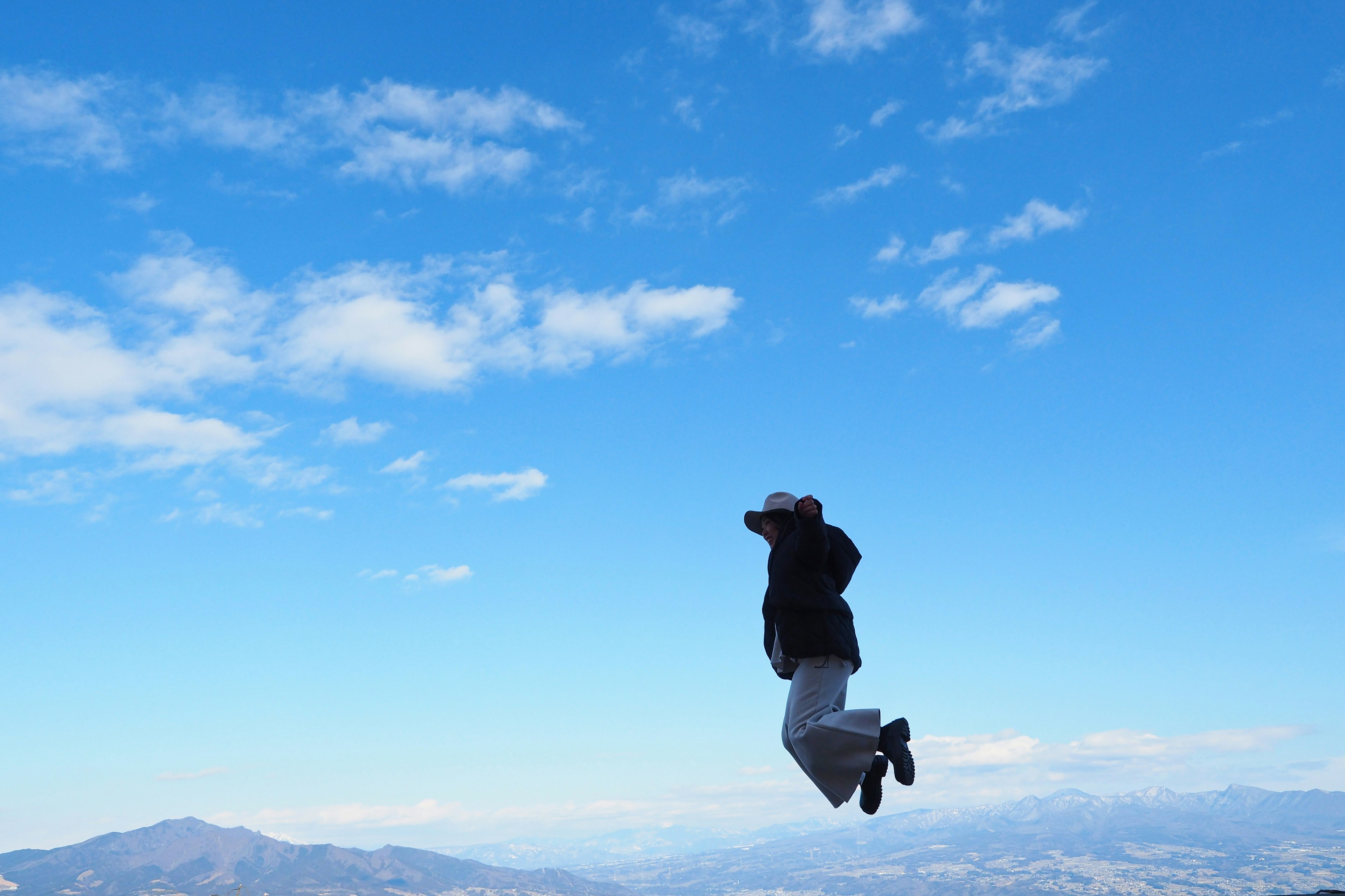 Une personne sautant sous un ciel bleu clair