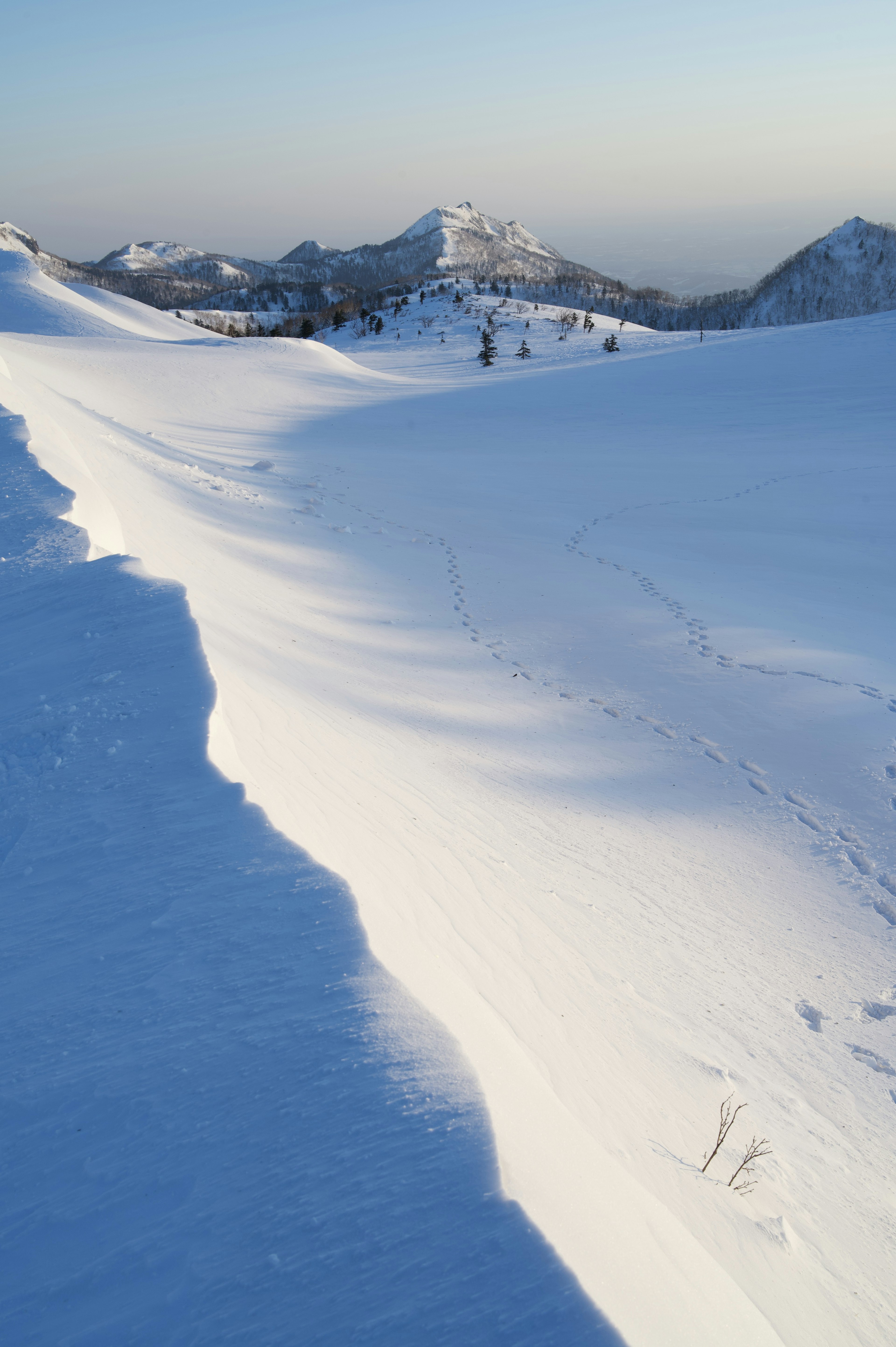 Paesaggio montano innevato con pendii morbidi