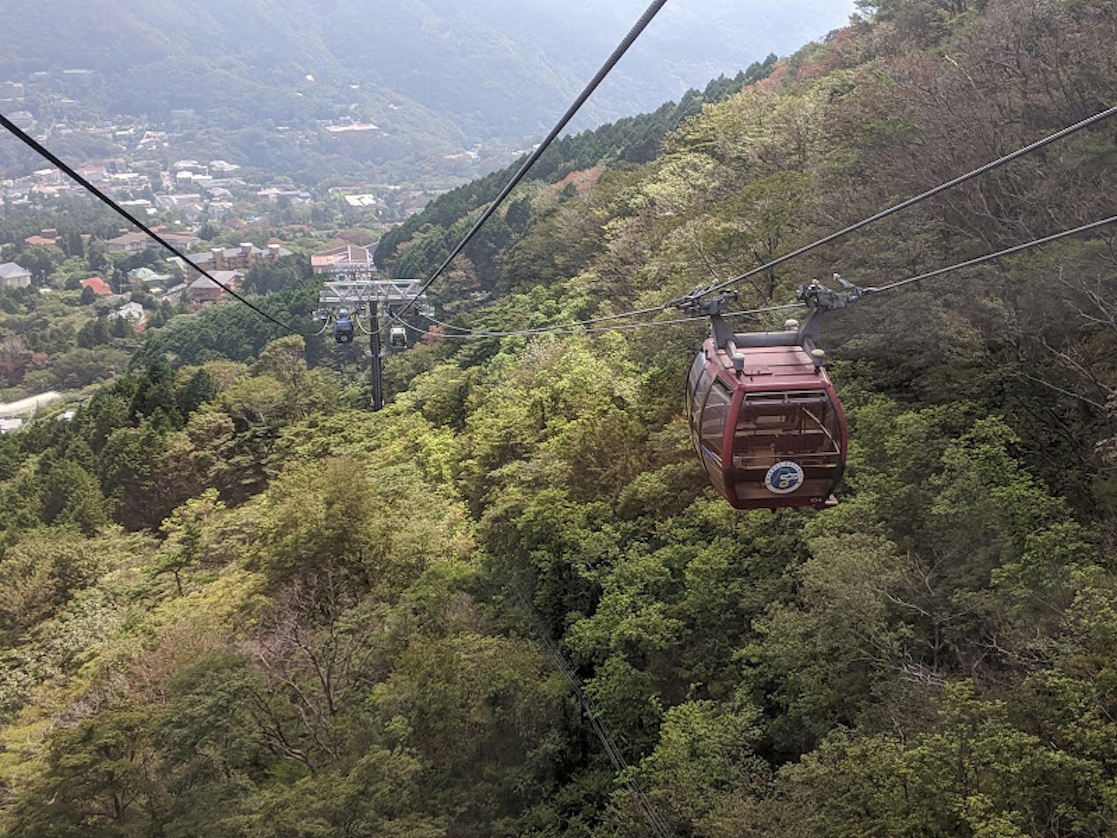 A cable car moving through lush green mountains