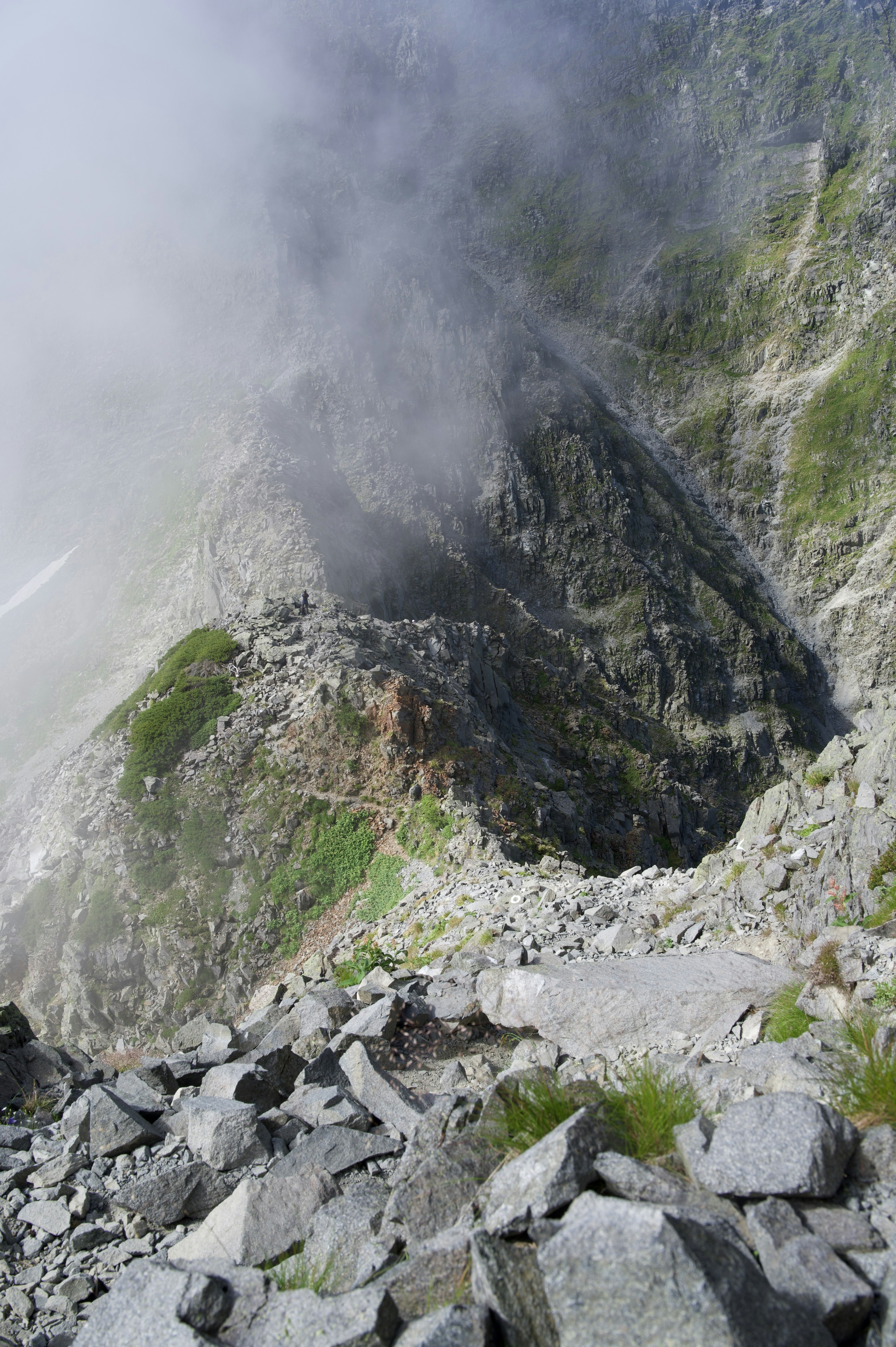 Foggy mountain slope with rocky terrain