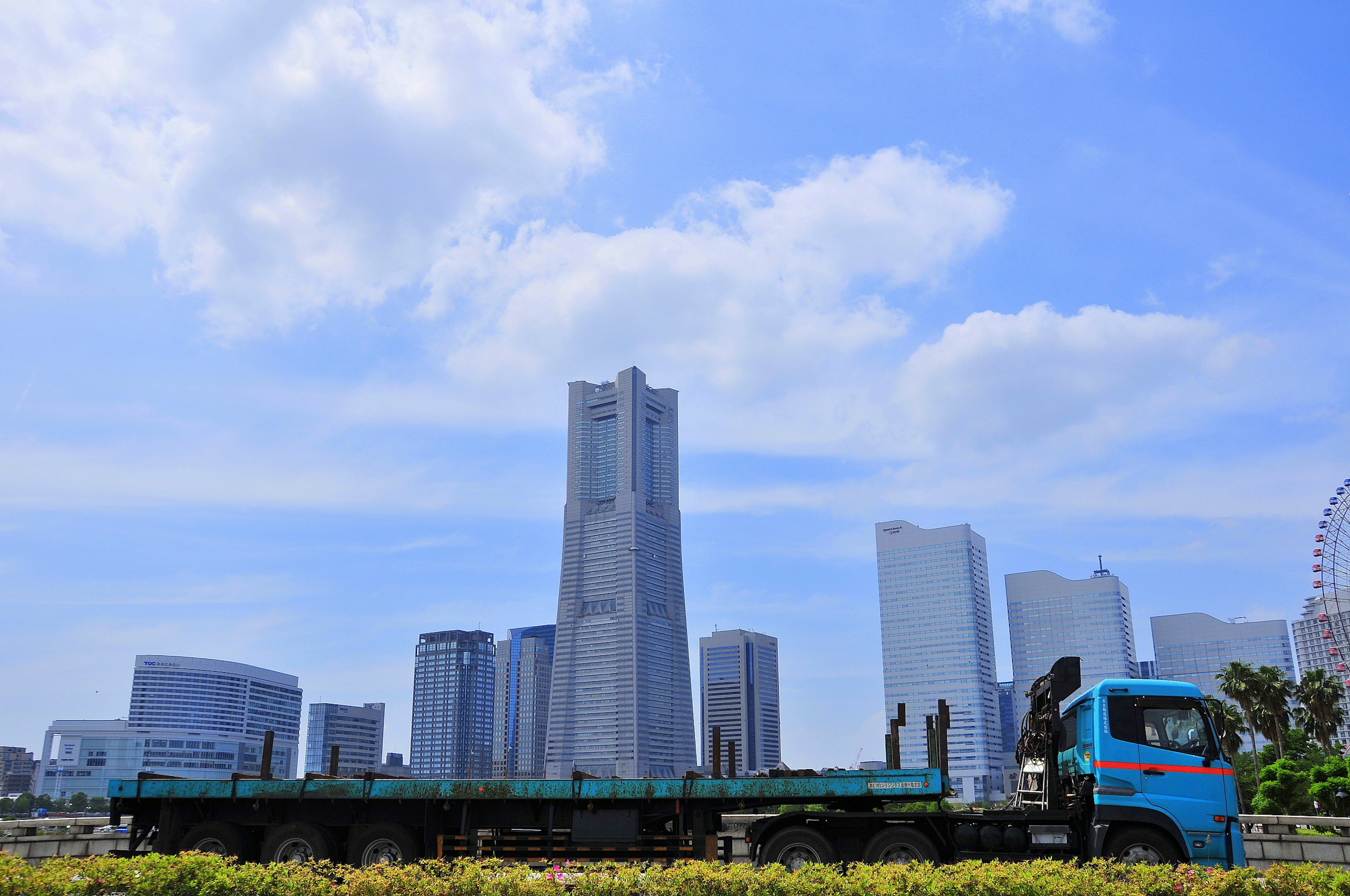 Paysage urbain avec des gratte-ciels modernes et un camion sous un ciel bleu