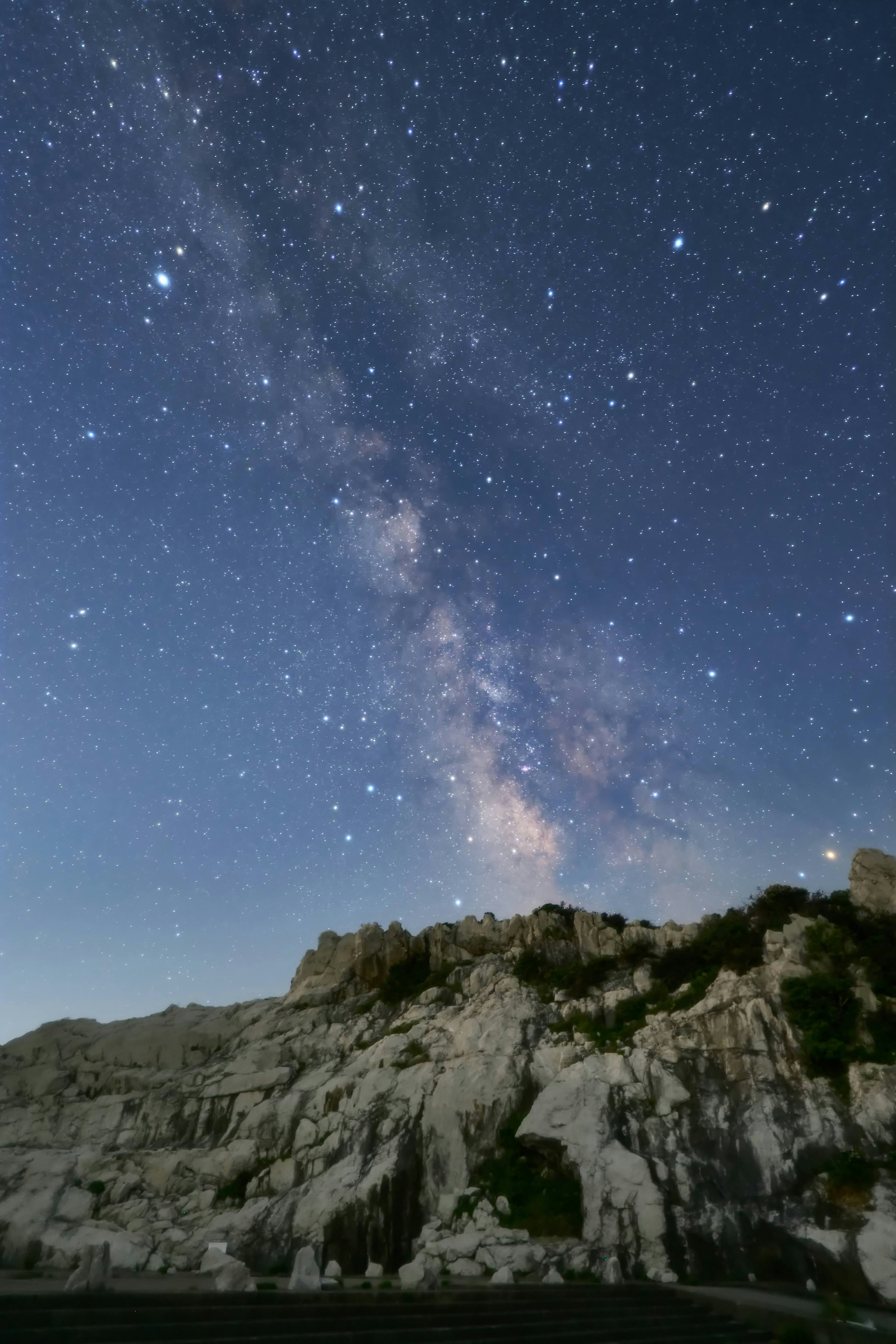 Nächtliche Szene mit sternenklarem Himmel und felsiger Landschaft