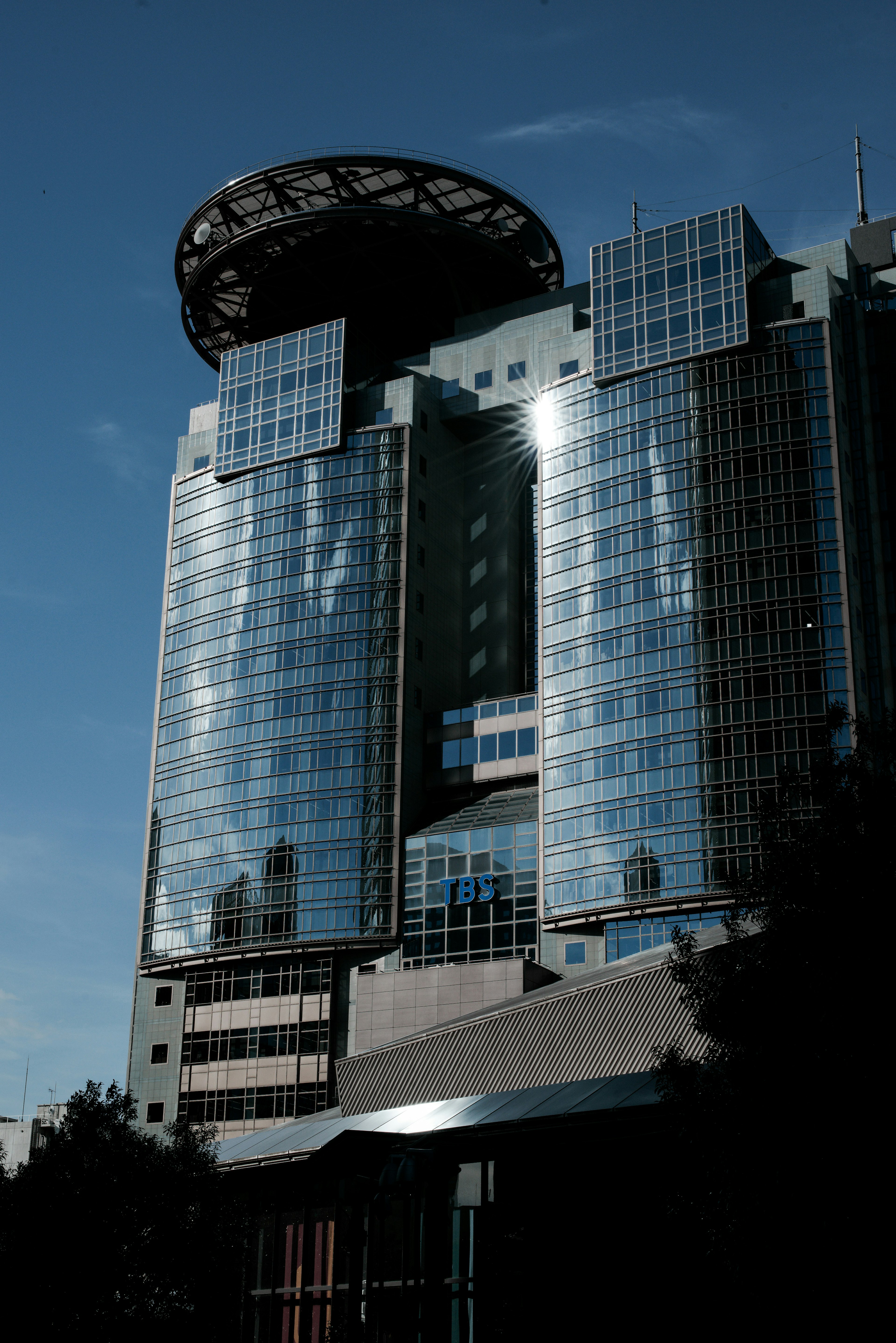 High-rise building with glass facade and circular rooftop structure