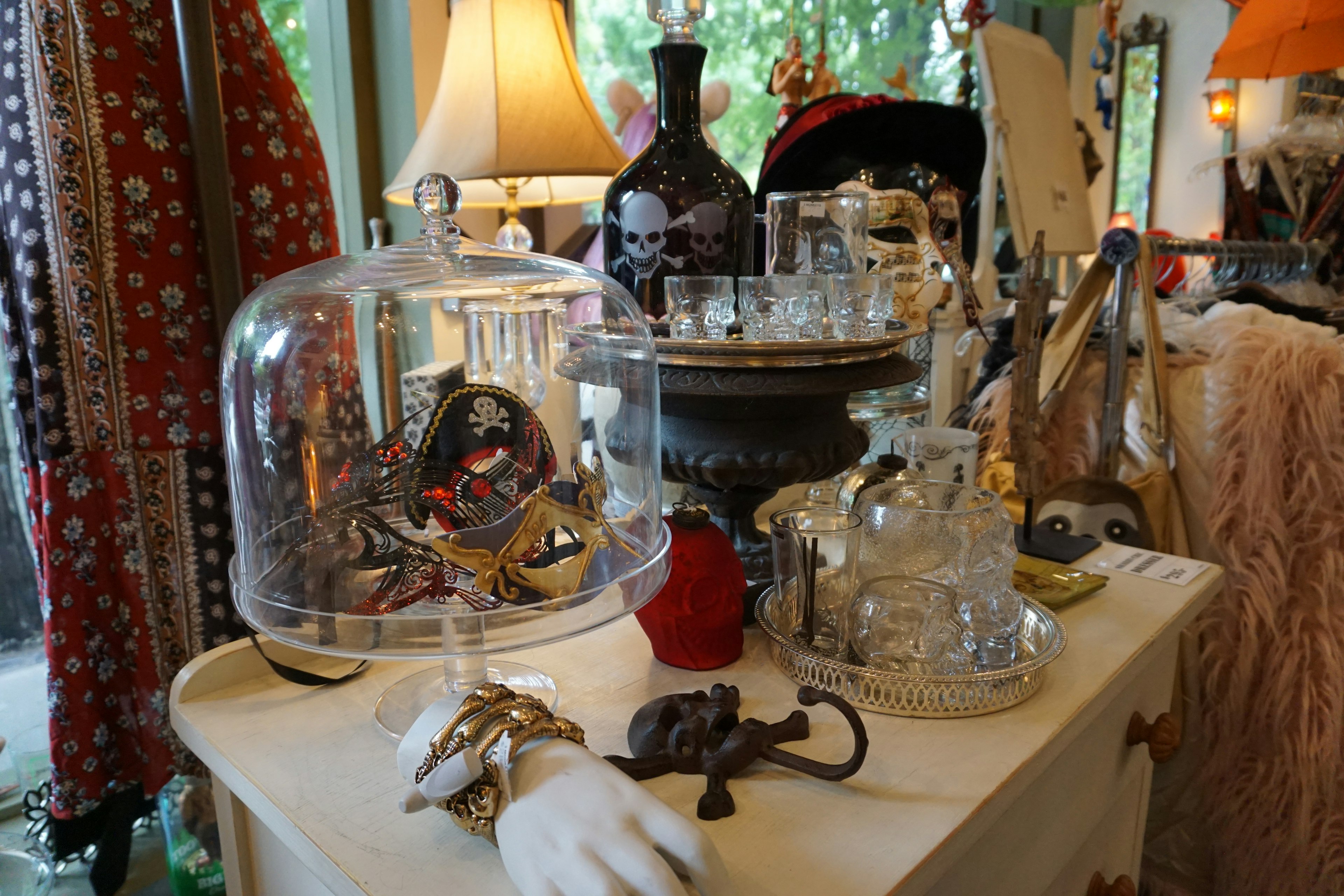 Une table remplie d'objets anciens sous un dôme en verre avec divers objets décoratifs