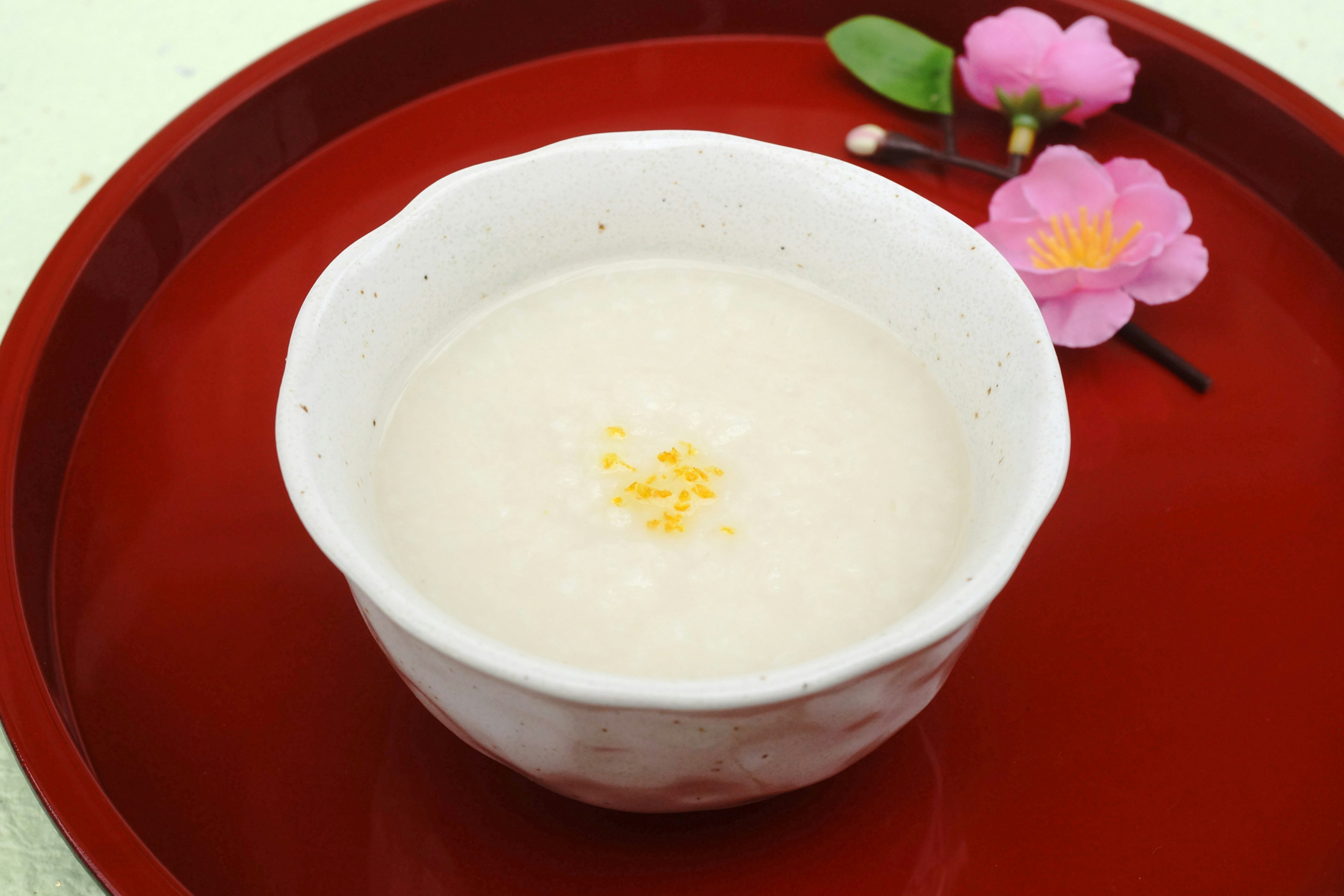 Porridge de arroz dulce servido en un tazón blanco con flores decorativas