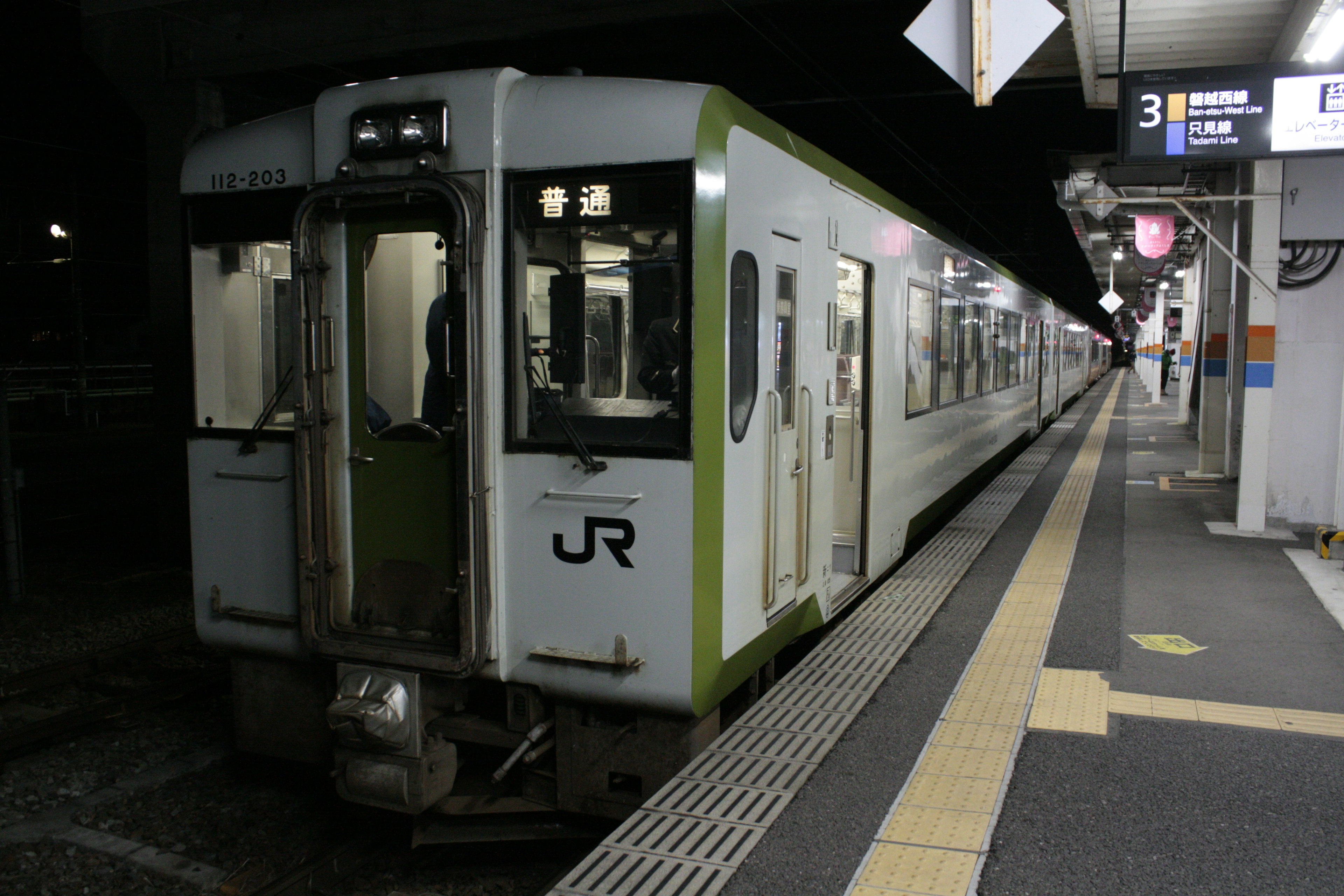 夜の駅で停車中のJR列車の側面