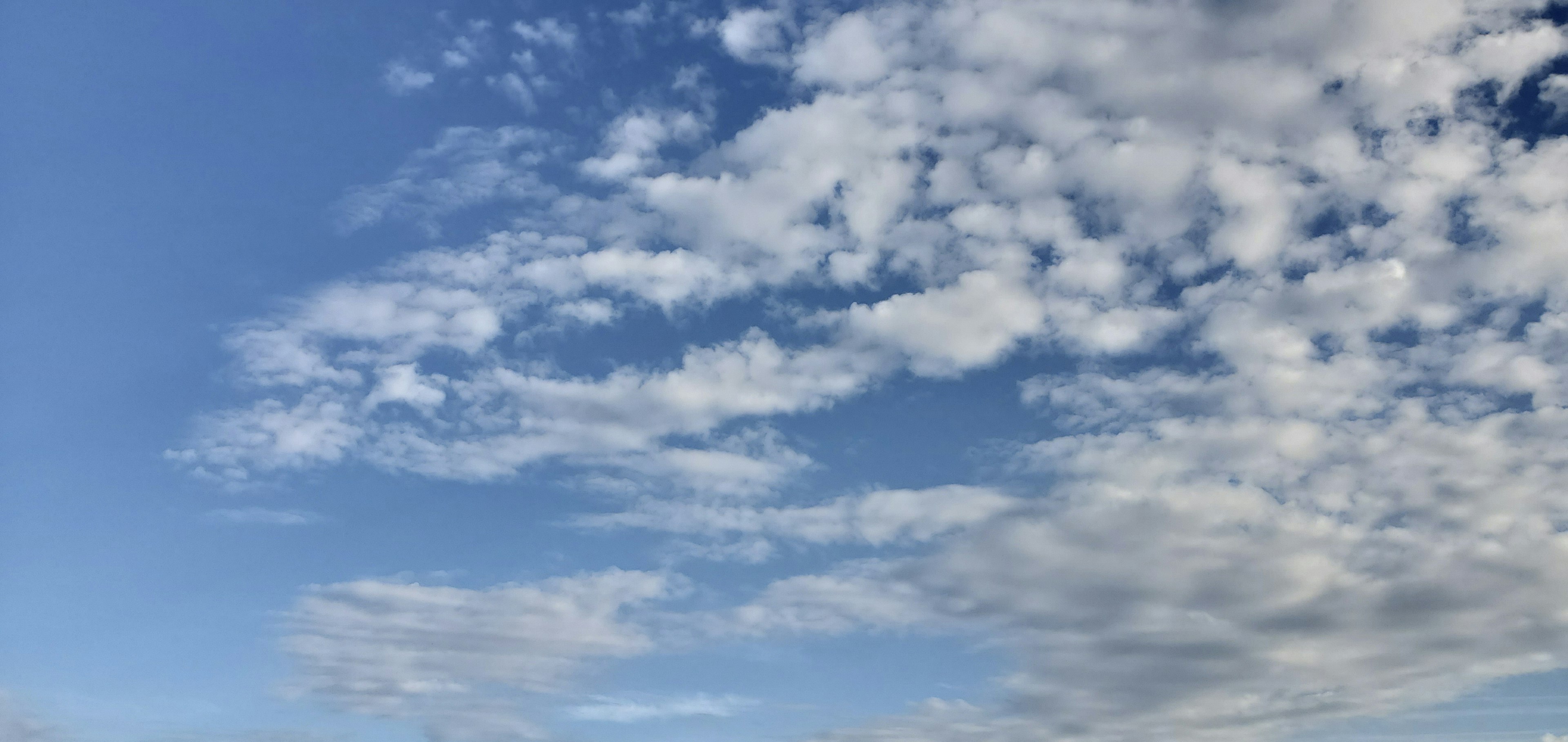 Pemandangan dengan awan putih tersebar di langit biru