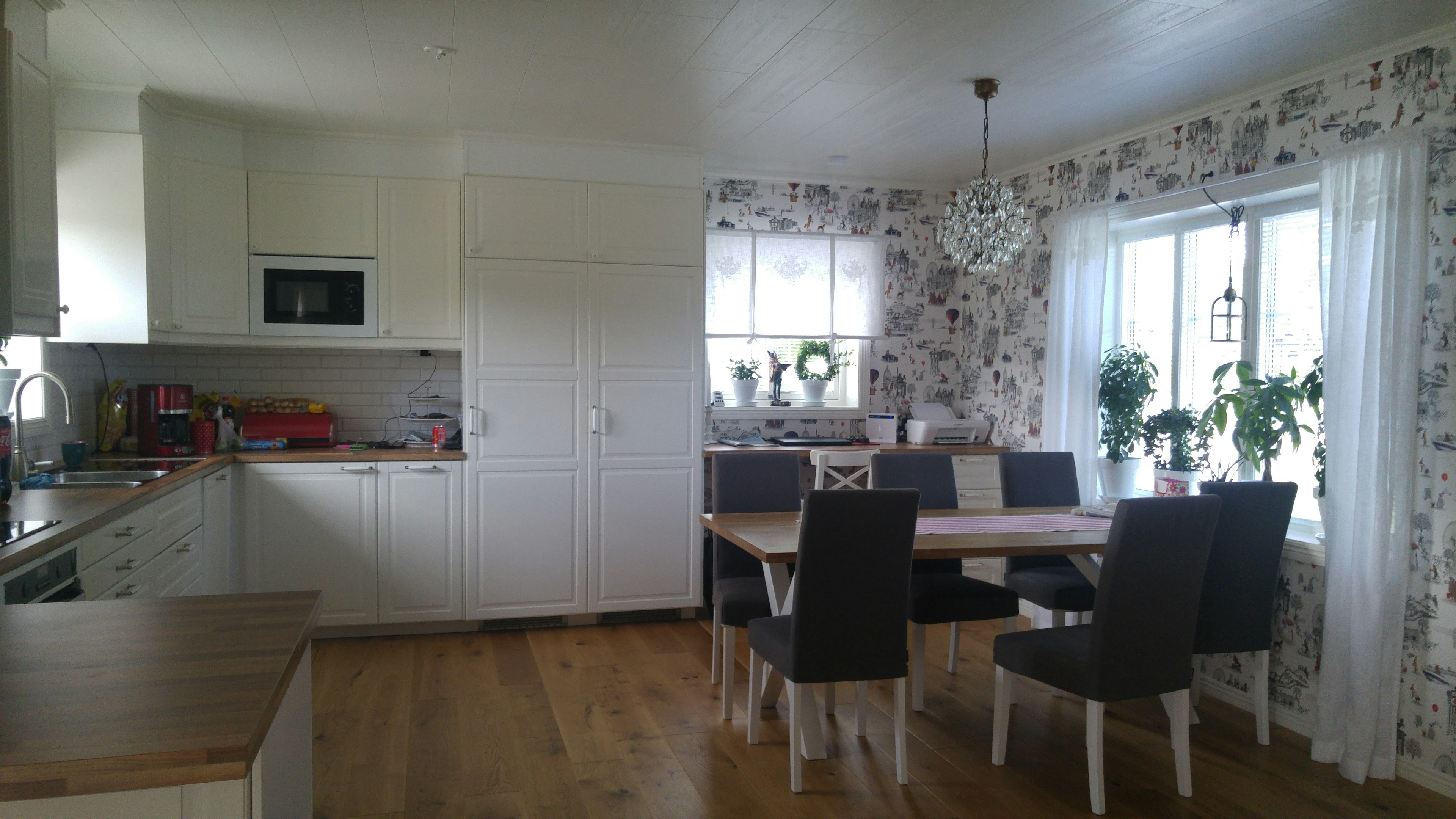 Bright modern kitchen and dining area with floral wallpaper