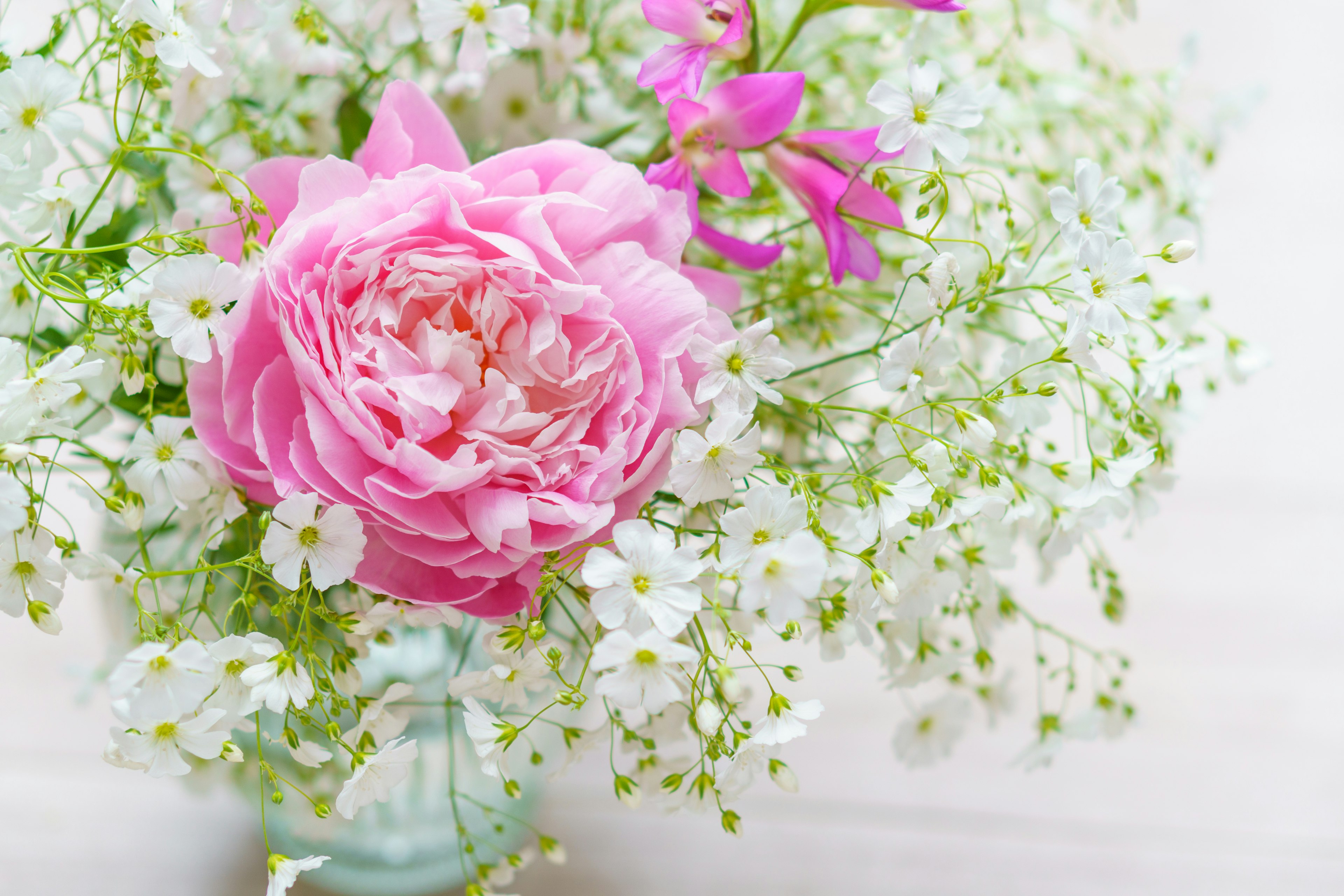 ピンクのバラと白い小花が特徴的な花束