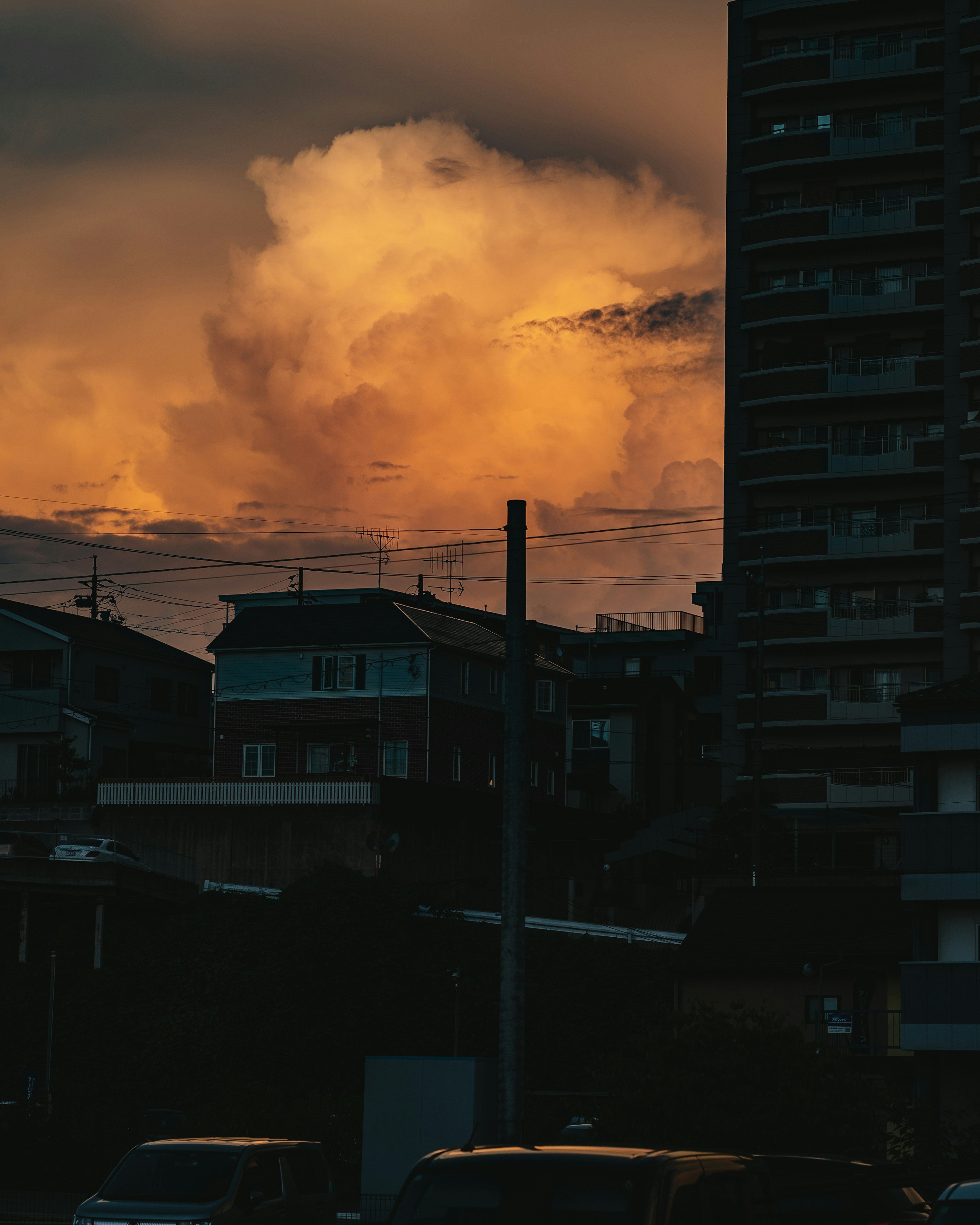 Silhouetted buildings against a sunset sky filled with orange clouds