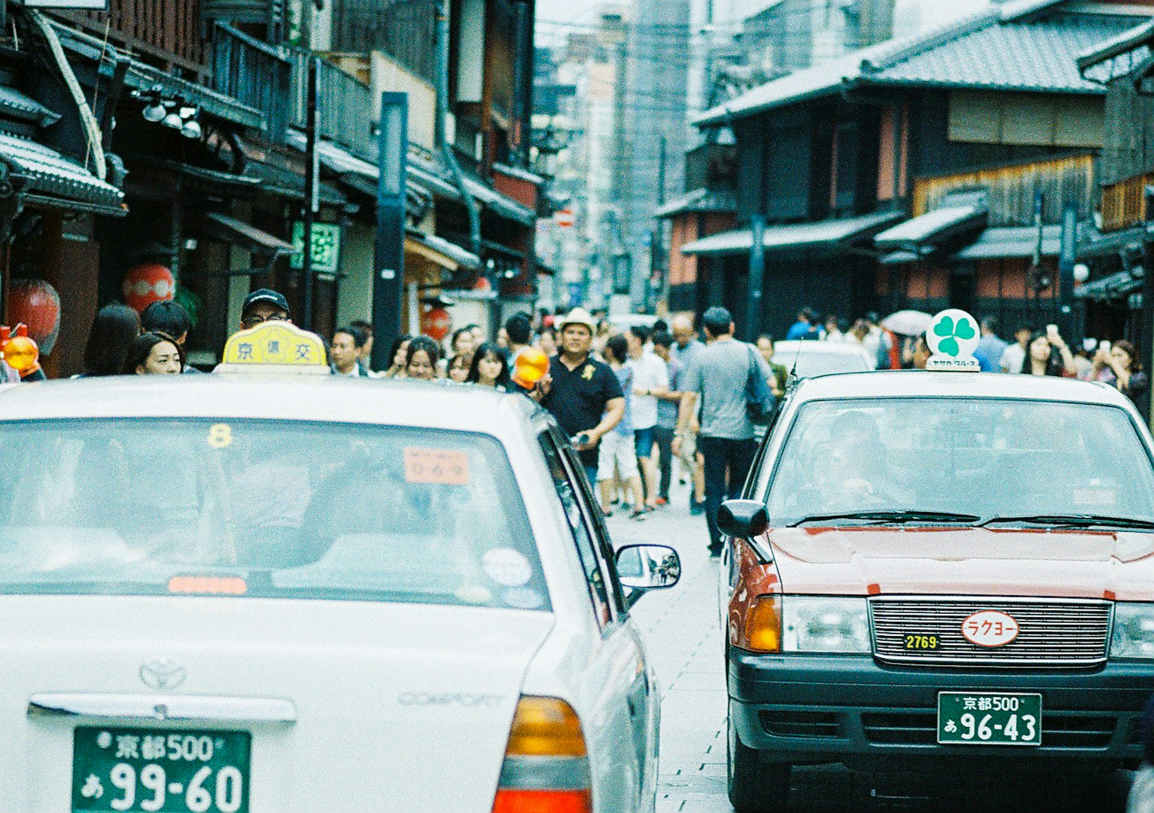 Taxis stopped on a crowded street surrounded by traditional buildings