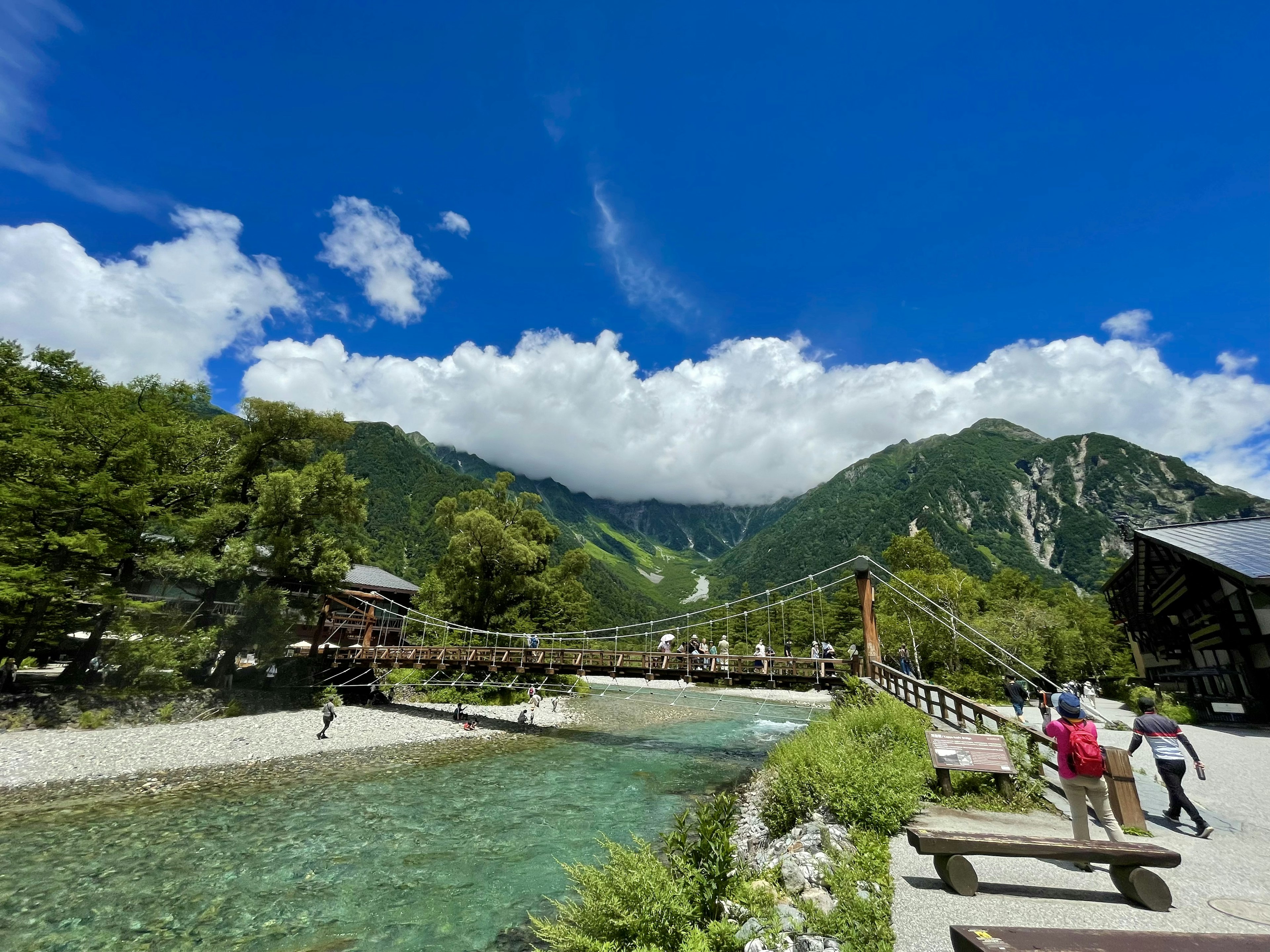 Vue pittoresque d'une rivière et de montagnes avec un pont suspendu