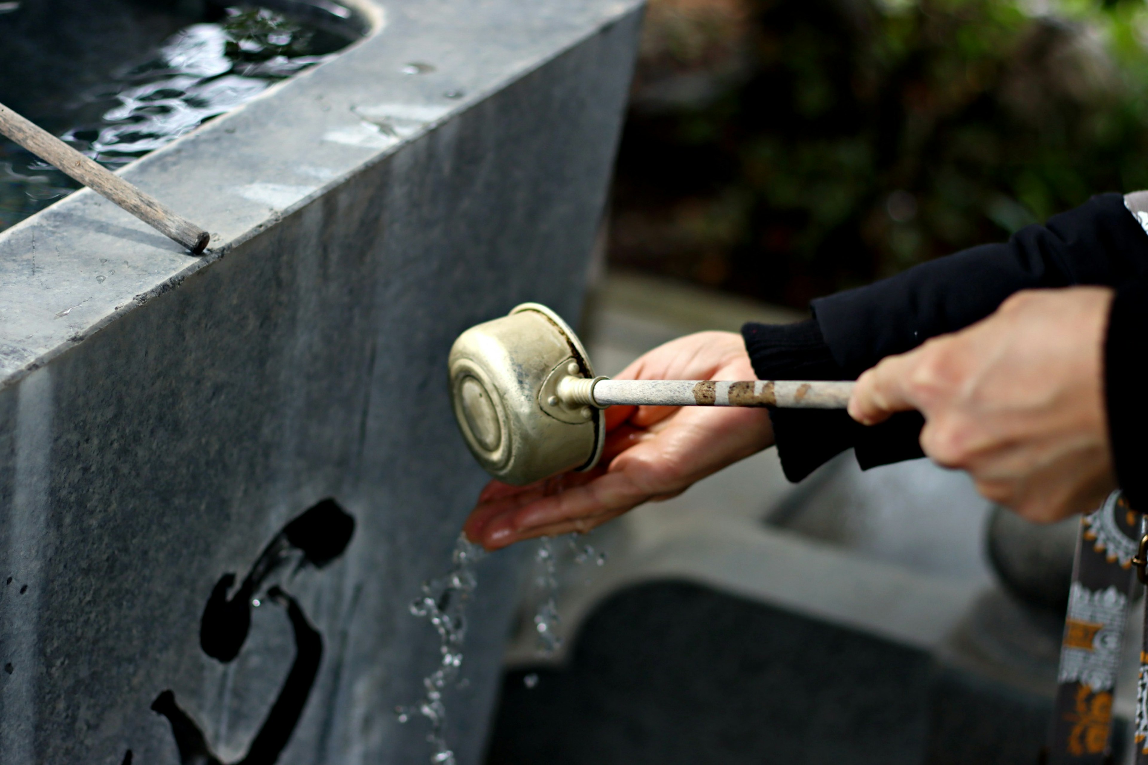 Image montrant une personne utilisant une louche à une bassine d'eau pour la purification