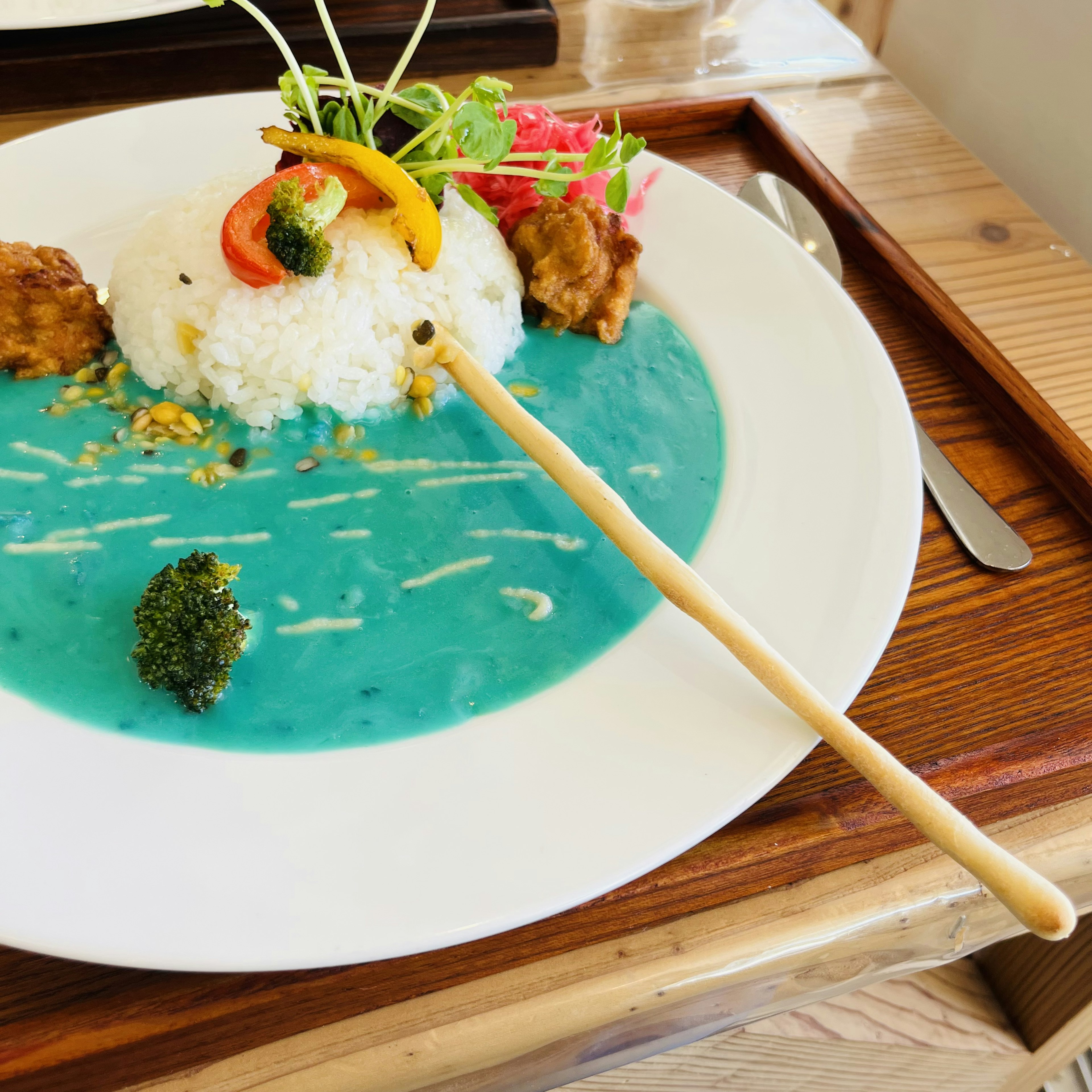 青いスープの皿に盛られたご飯と野菜のプレート