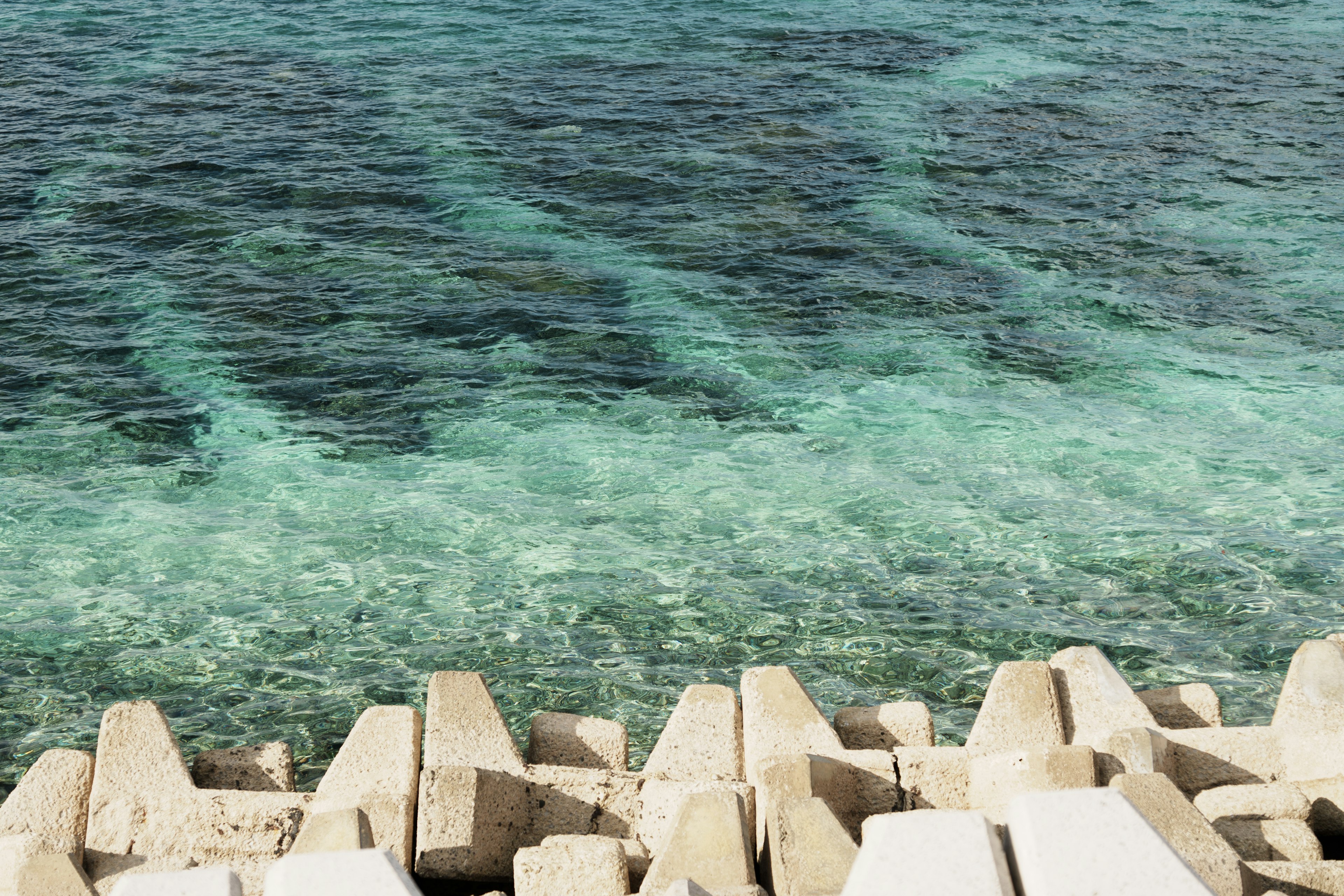 Eau turquoise claire avec un brise-lames blanc