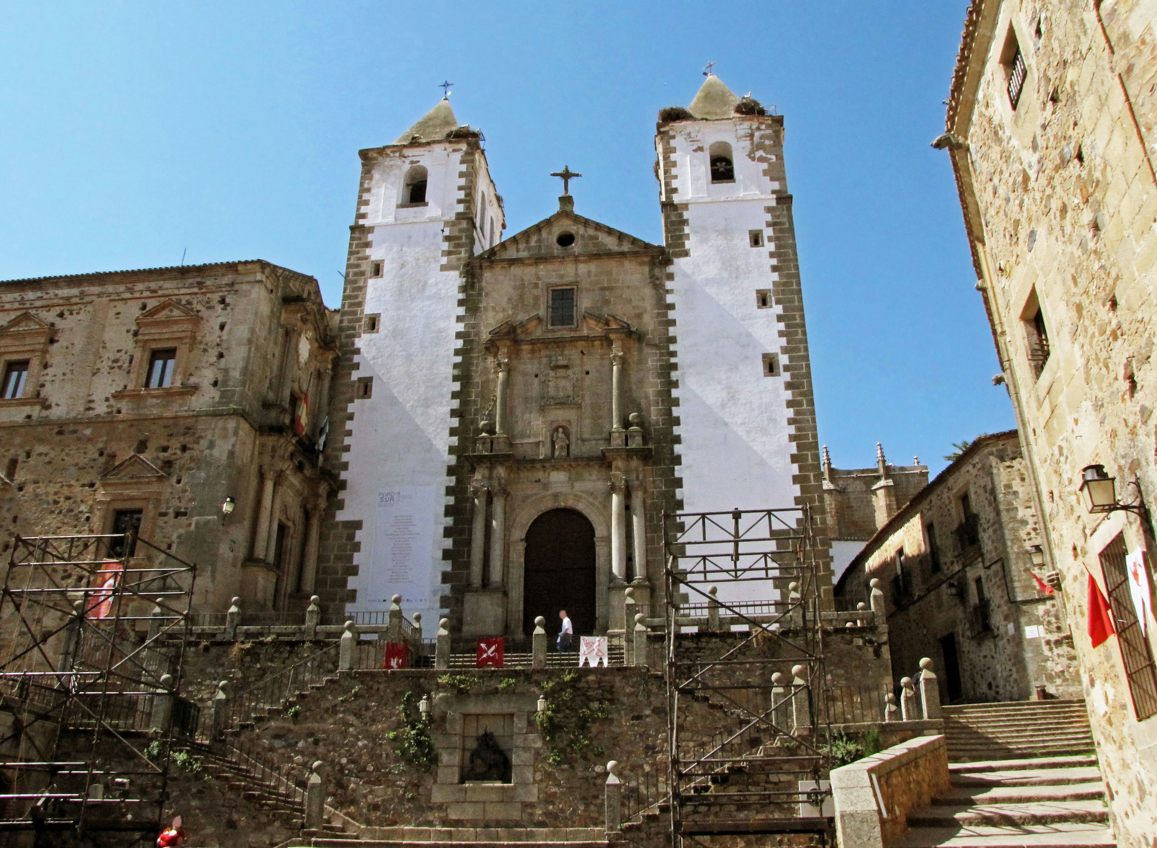 Iglesia histórica de piedra con torres gemelas y andamios