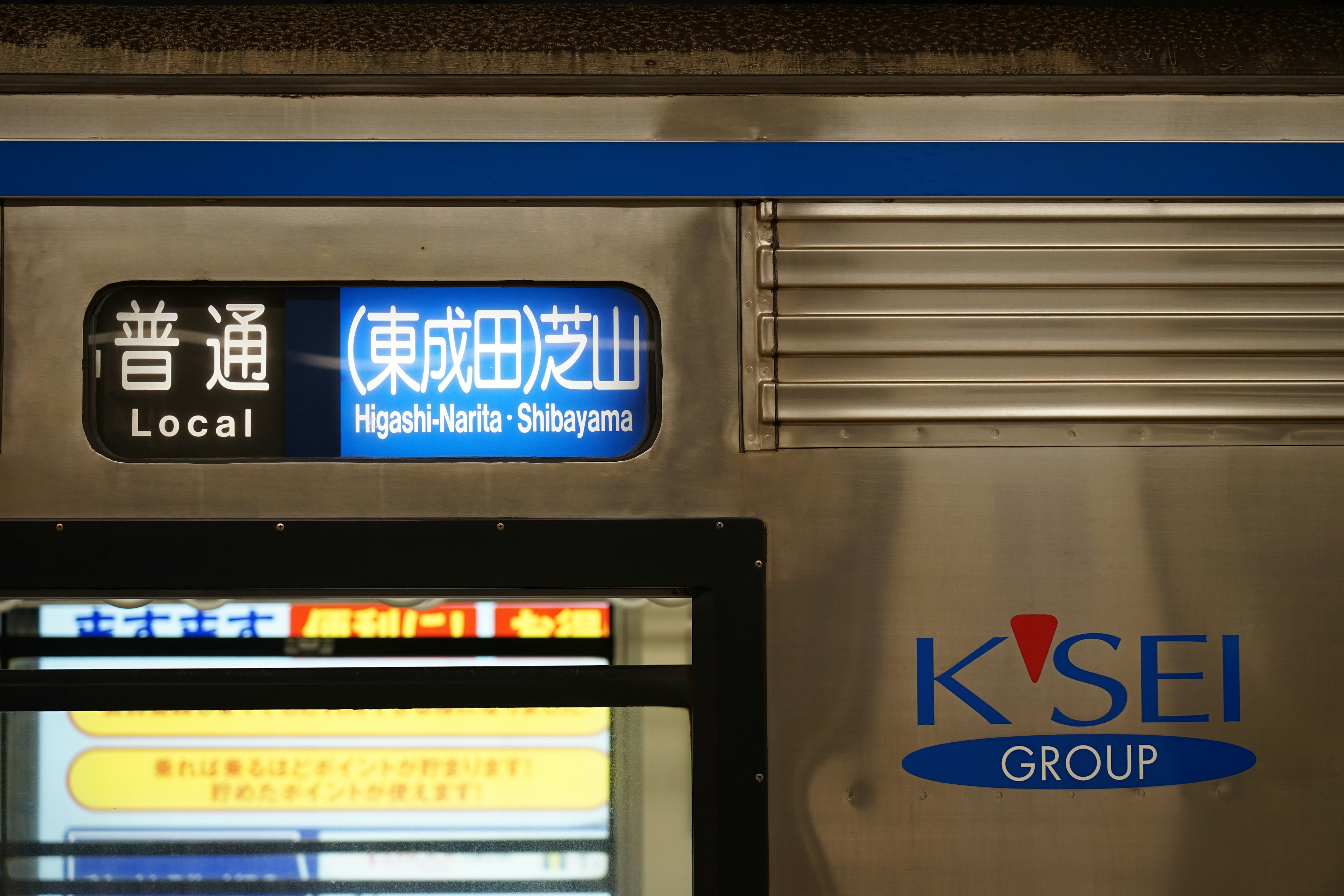 Local train sign and station name on the side of a Keisei Group train