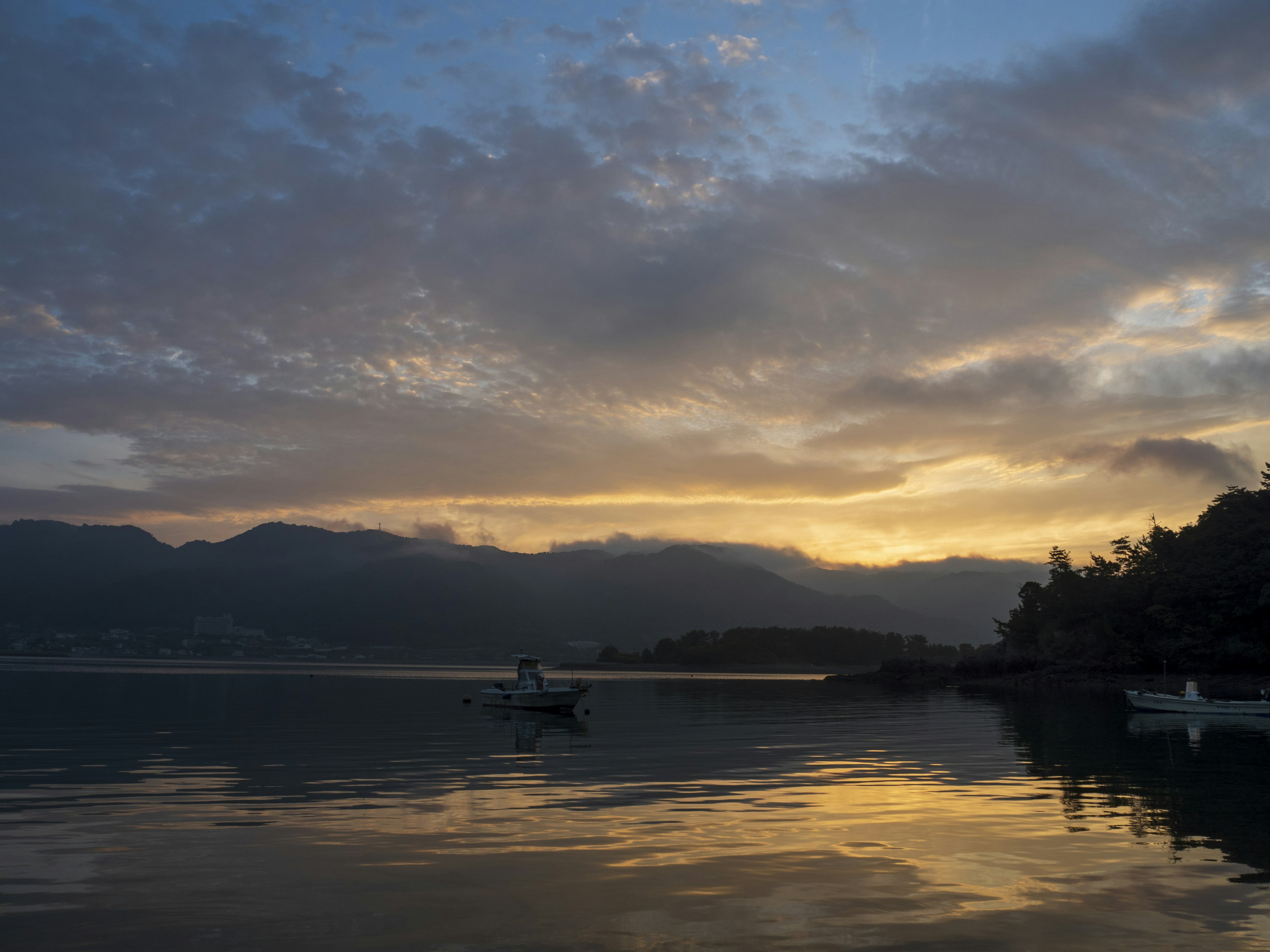 Pemandangan danau tenang dengan refleksi matahari terbenam yang indah