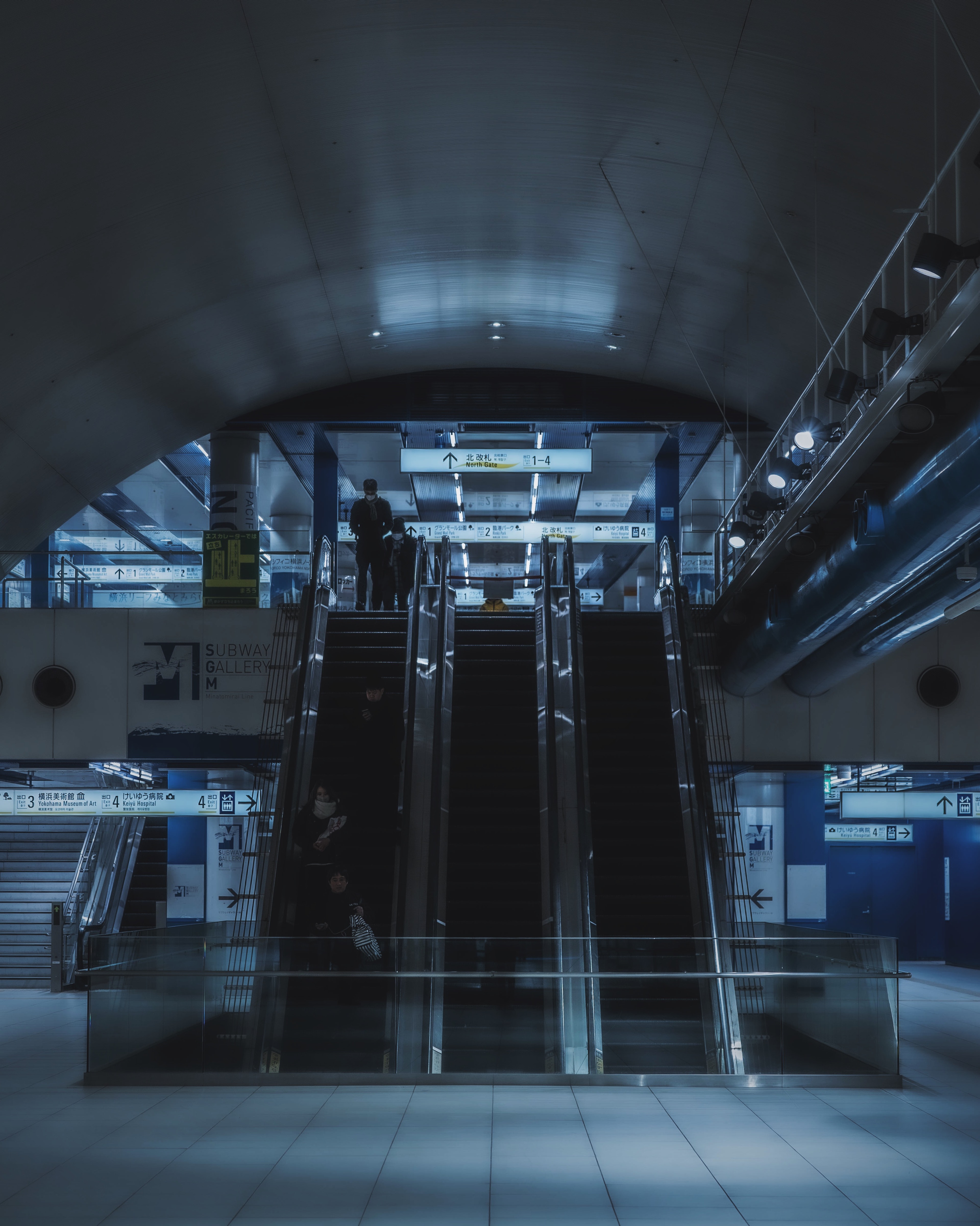 Dark train station featuring modern escalators and architectural design