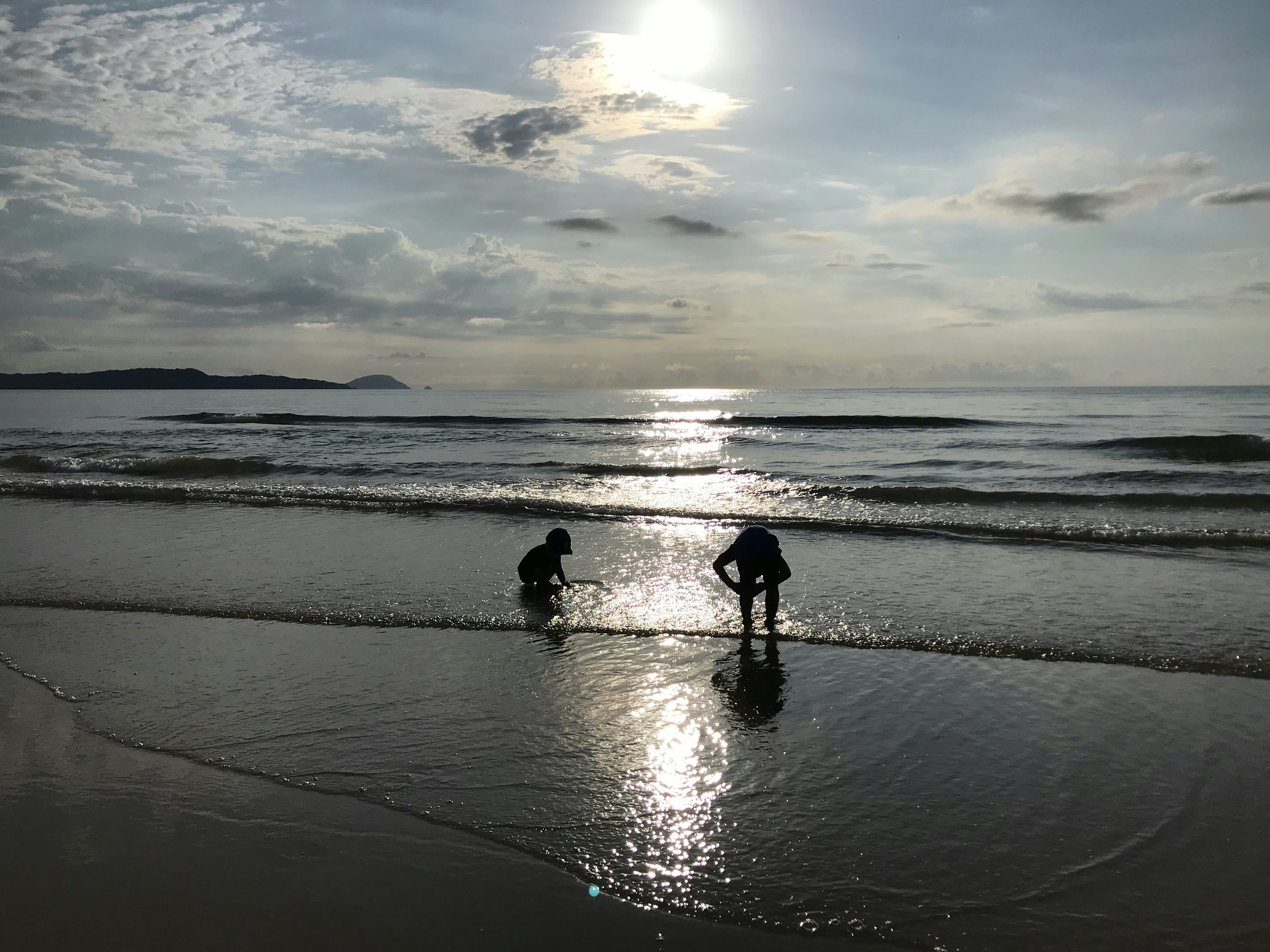 Bambini che giocano sulla spiaggia con riflesso del sole