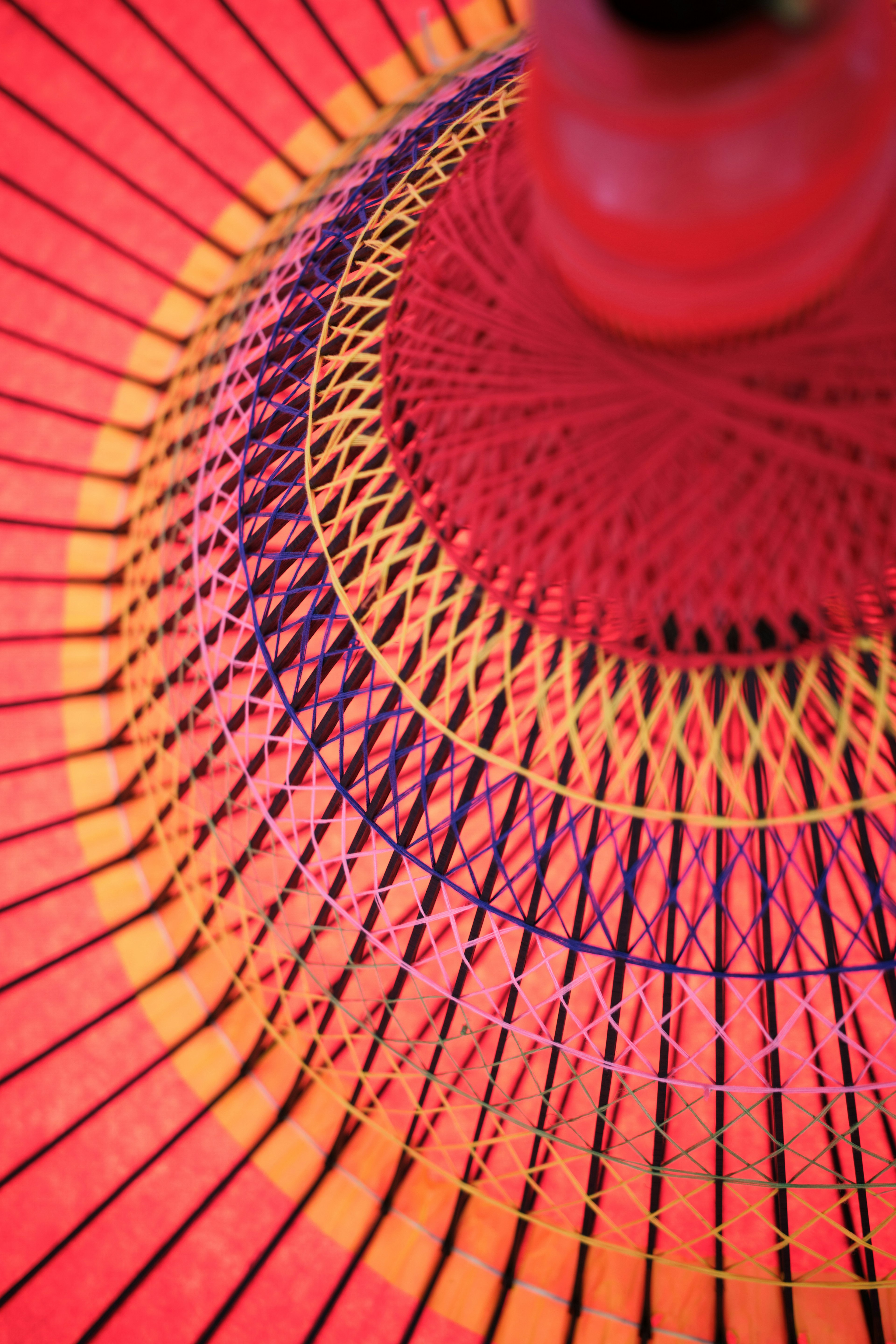 Motif détaillé de l'intérieur d'un parapluie en teintes rouges et oranges