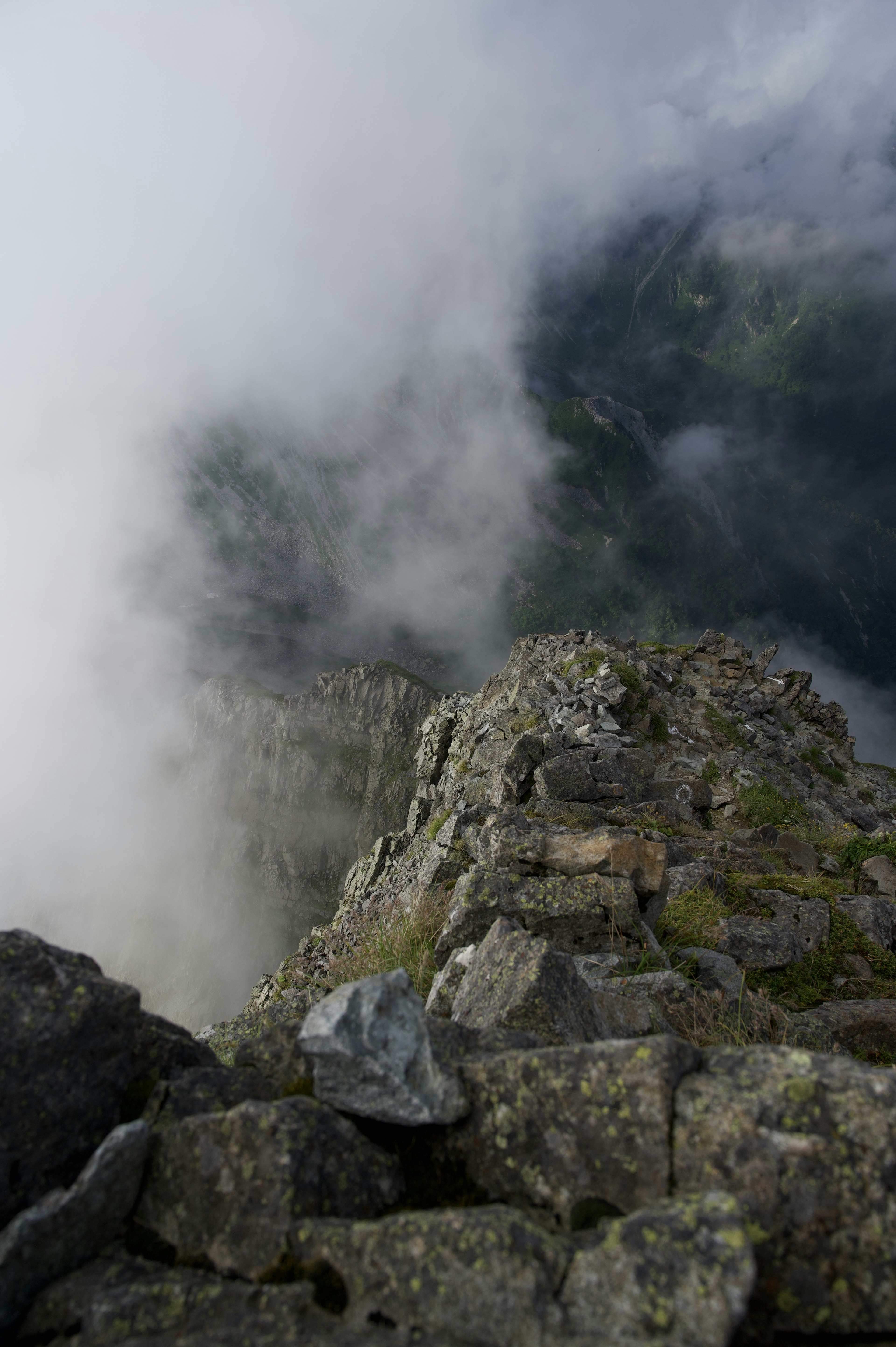 Puncak gunung berbatu yang diselimuti awan