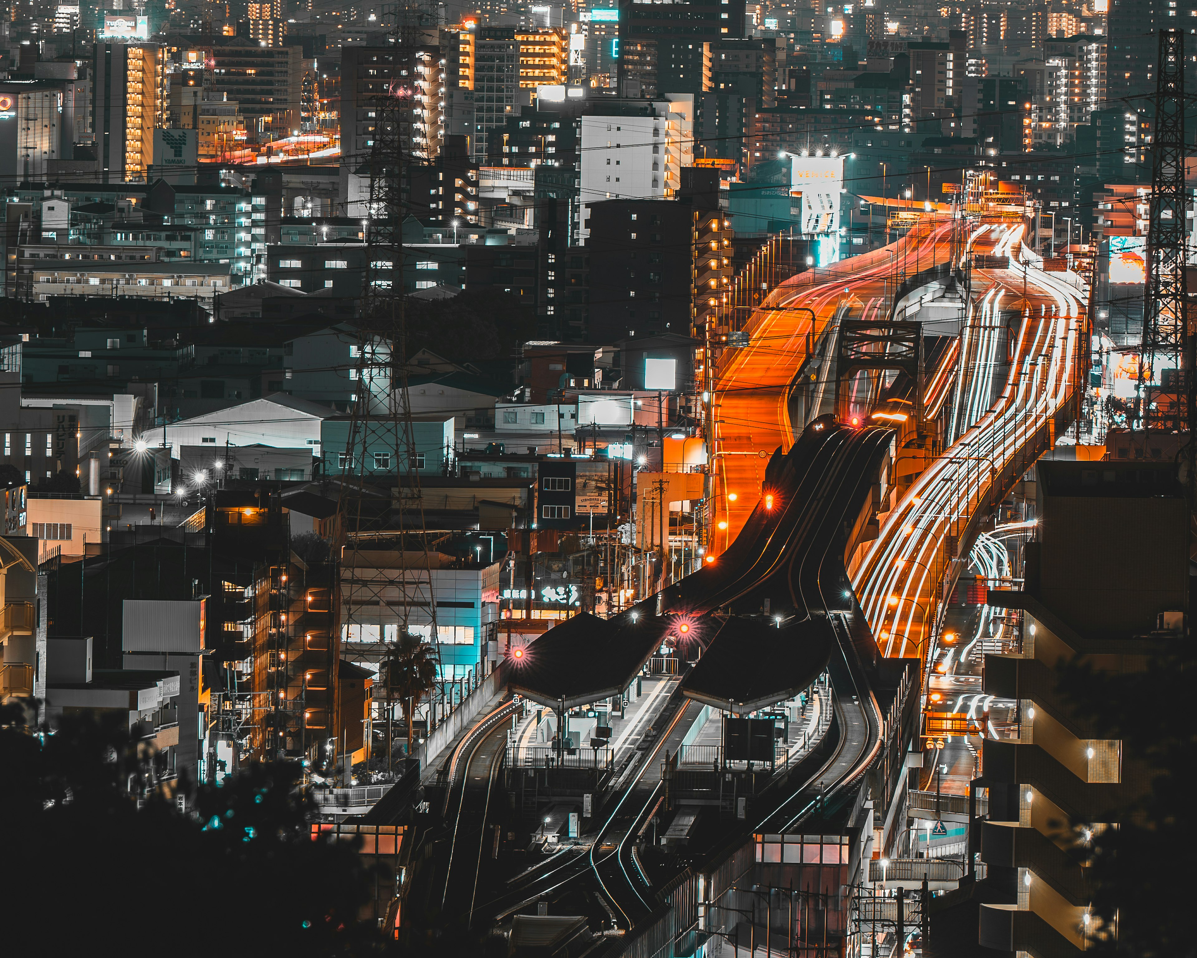 夜间生动的城市景观，特色有照亮的火车轨道和建筑物