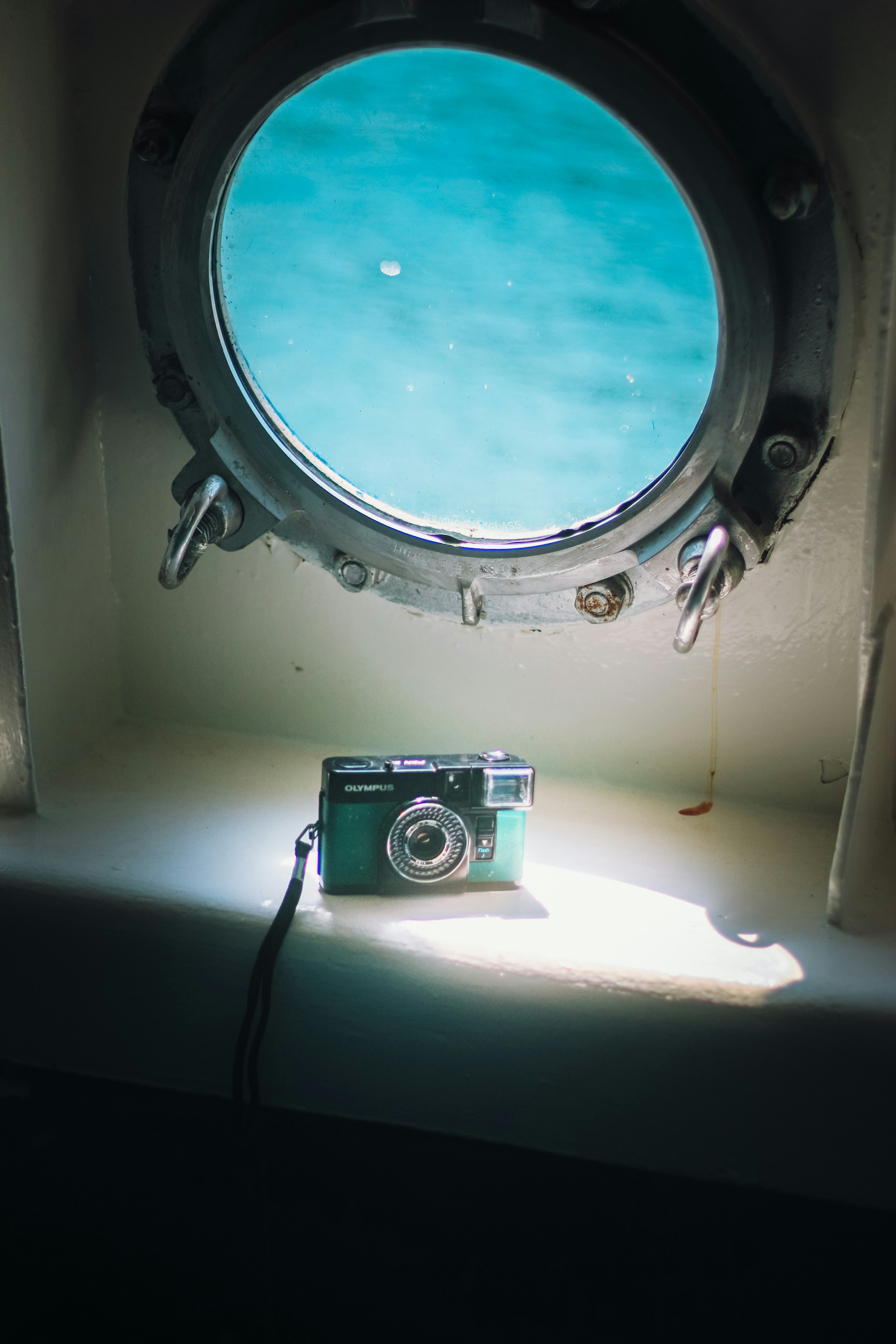 Appareil photo sur une table avec un hublot révélant de l'eau bleue