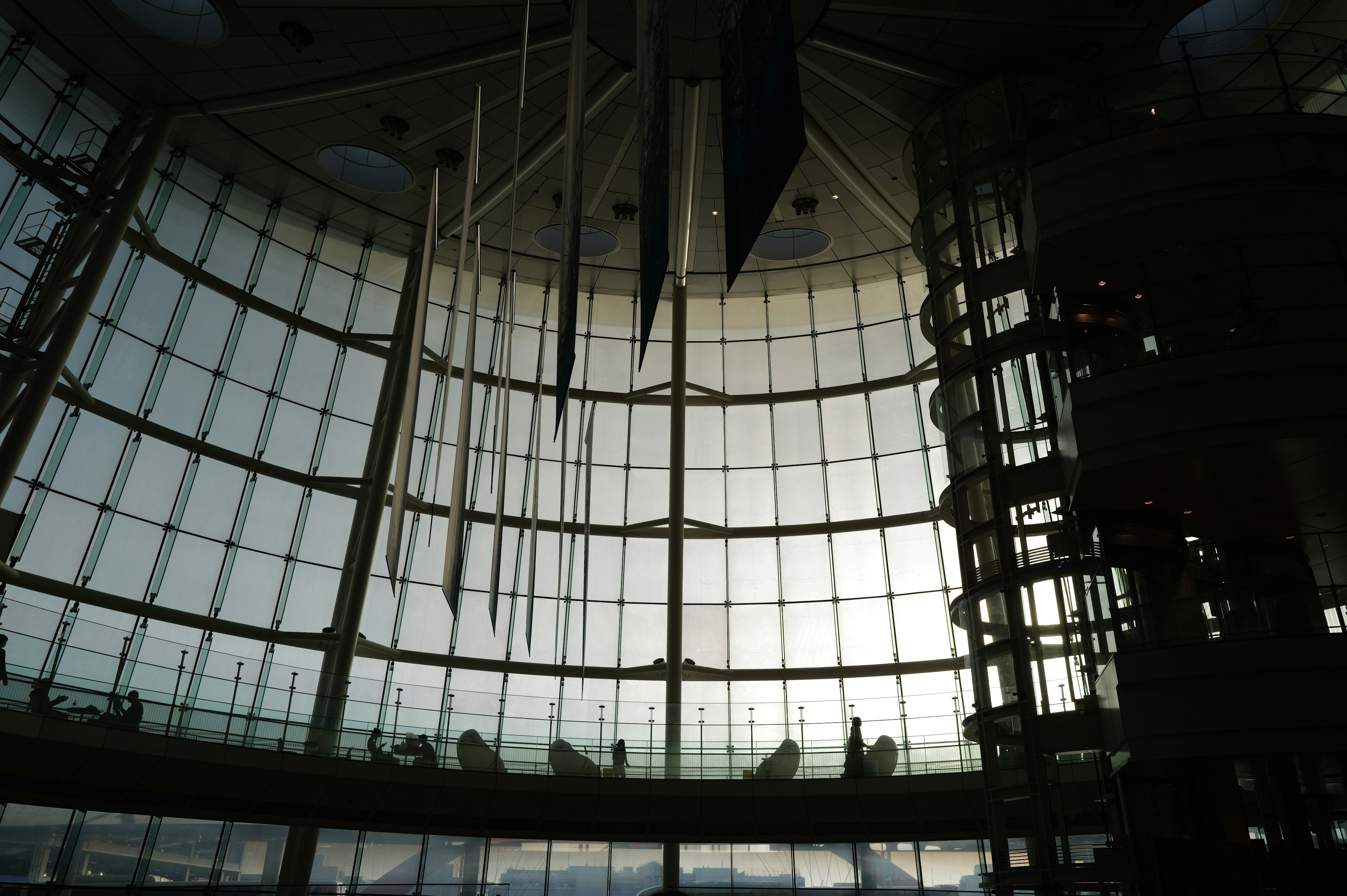 Interior of a modern building featuring glass walls and hanging decorations