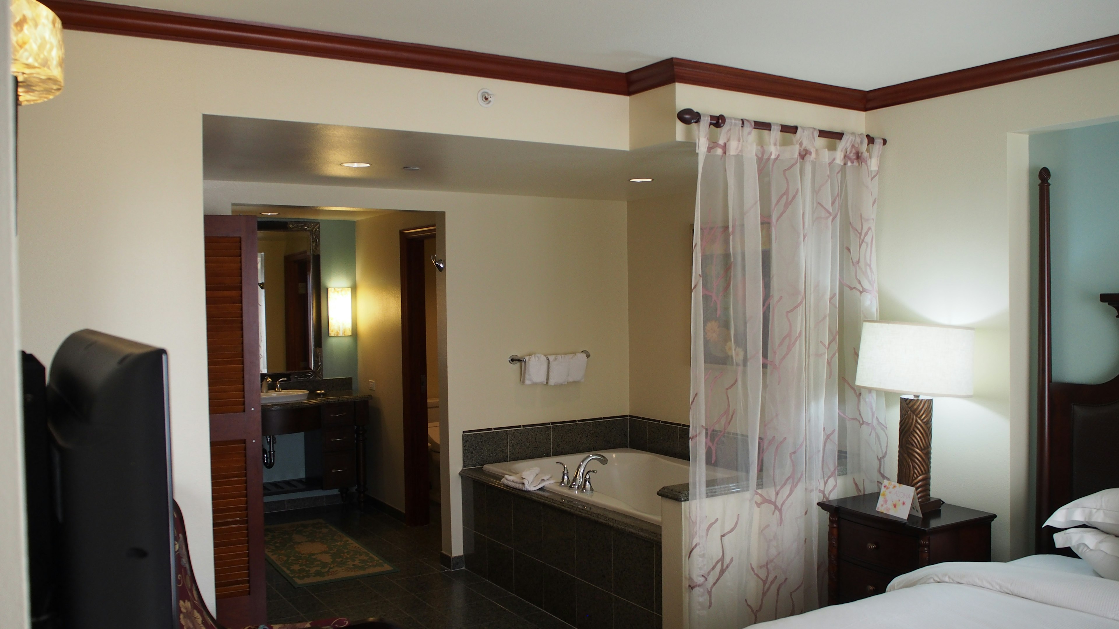 Brightly decorated hotel room featuring a visible bathroom with a bathtub