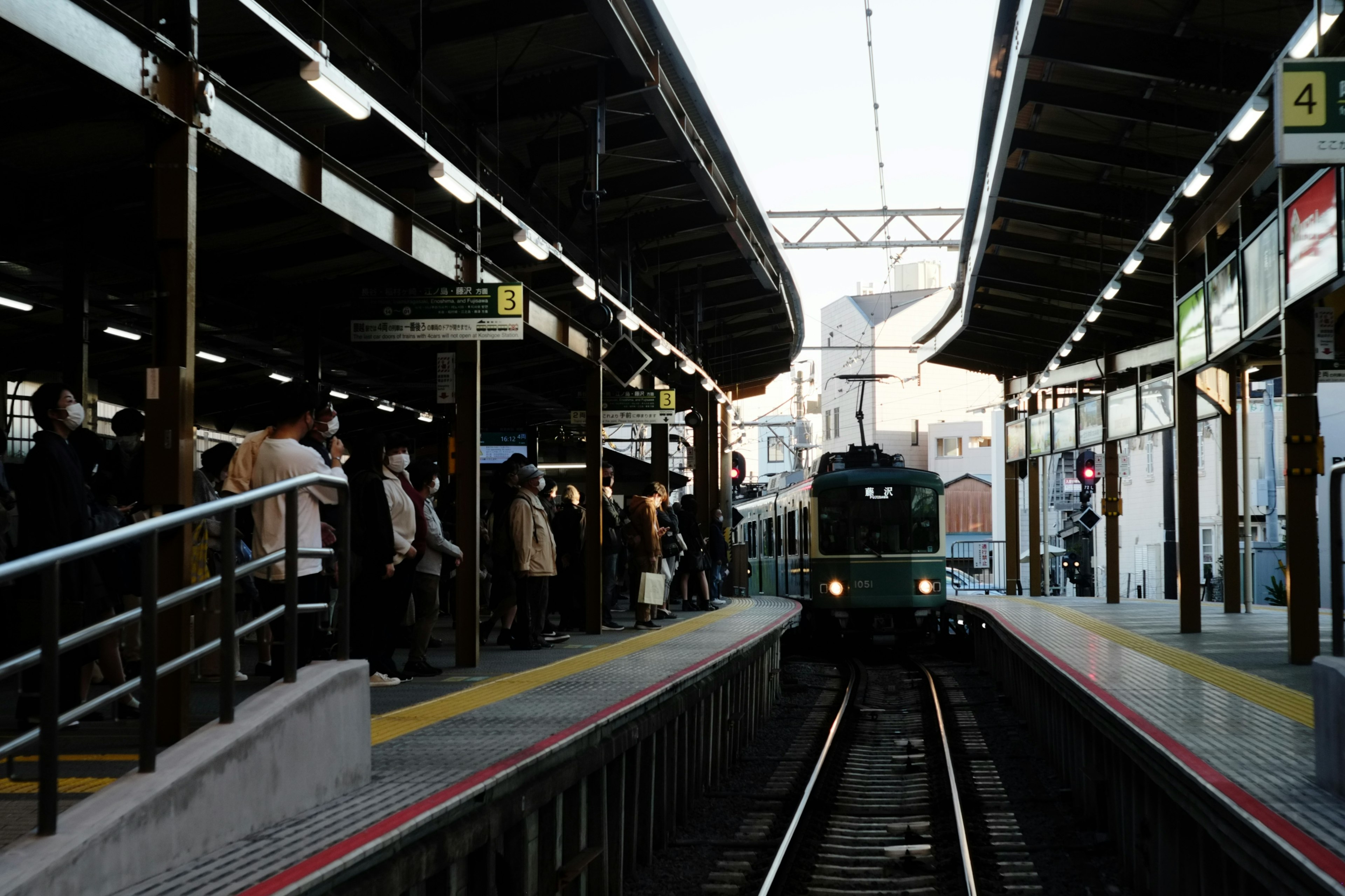 駅のプラットフォームにいる人々と近づく列車