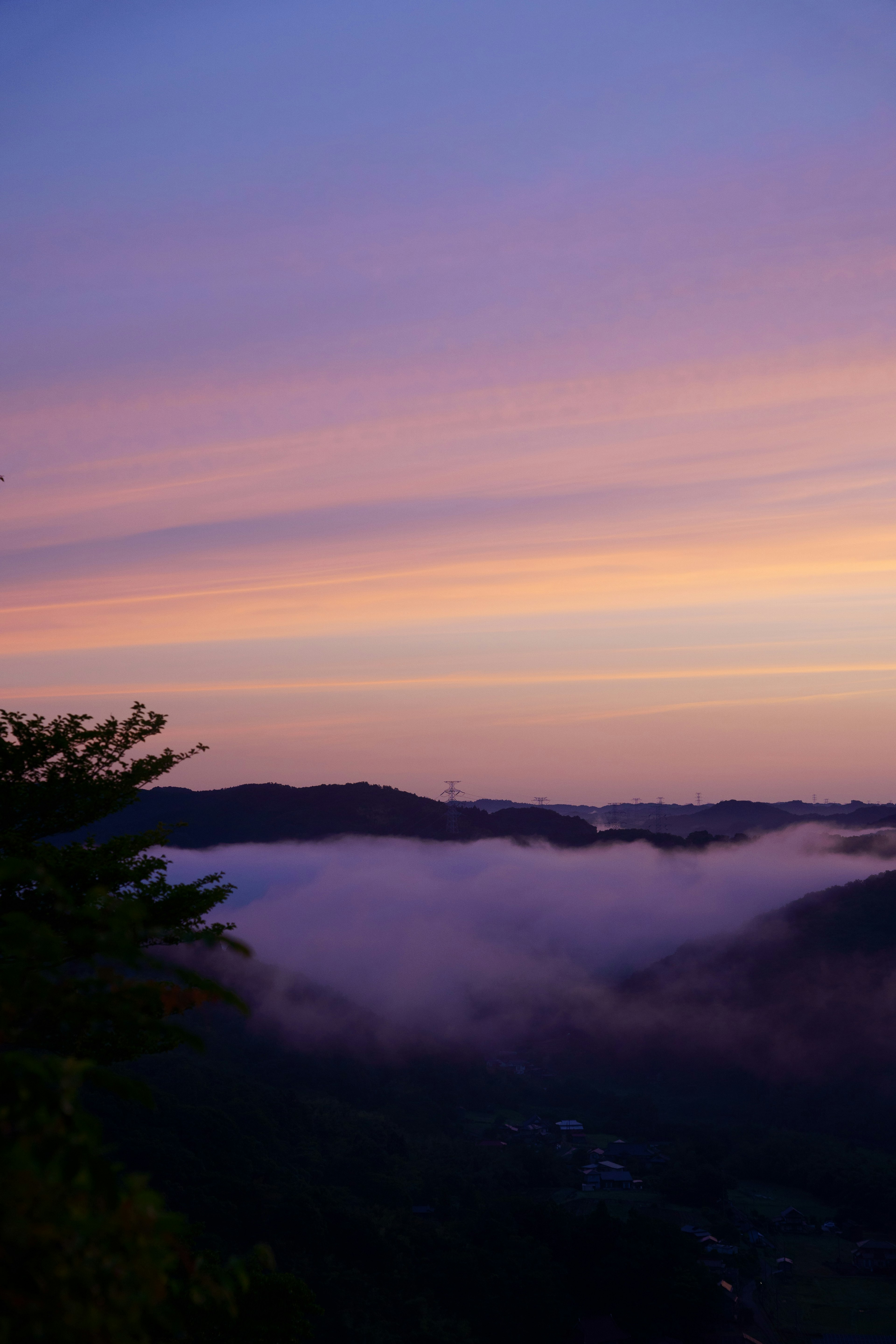 Hermoso cielo al atardecer con montañas y niebla cubriendo el valle