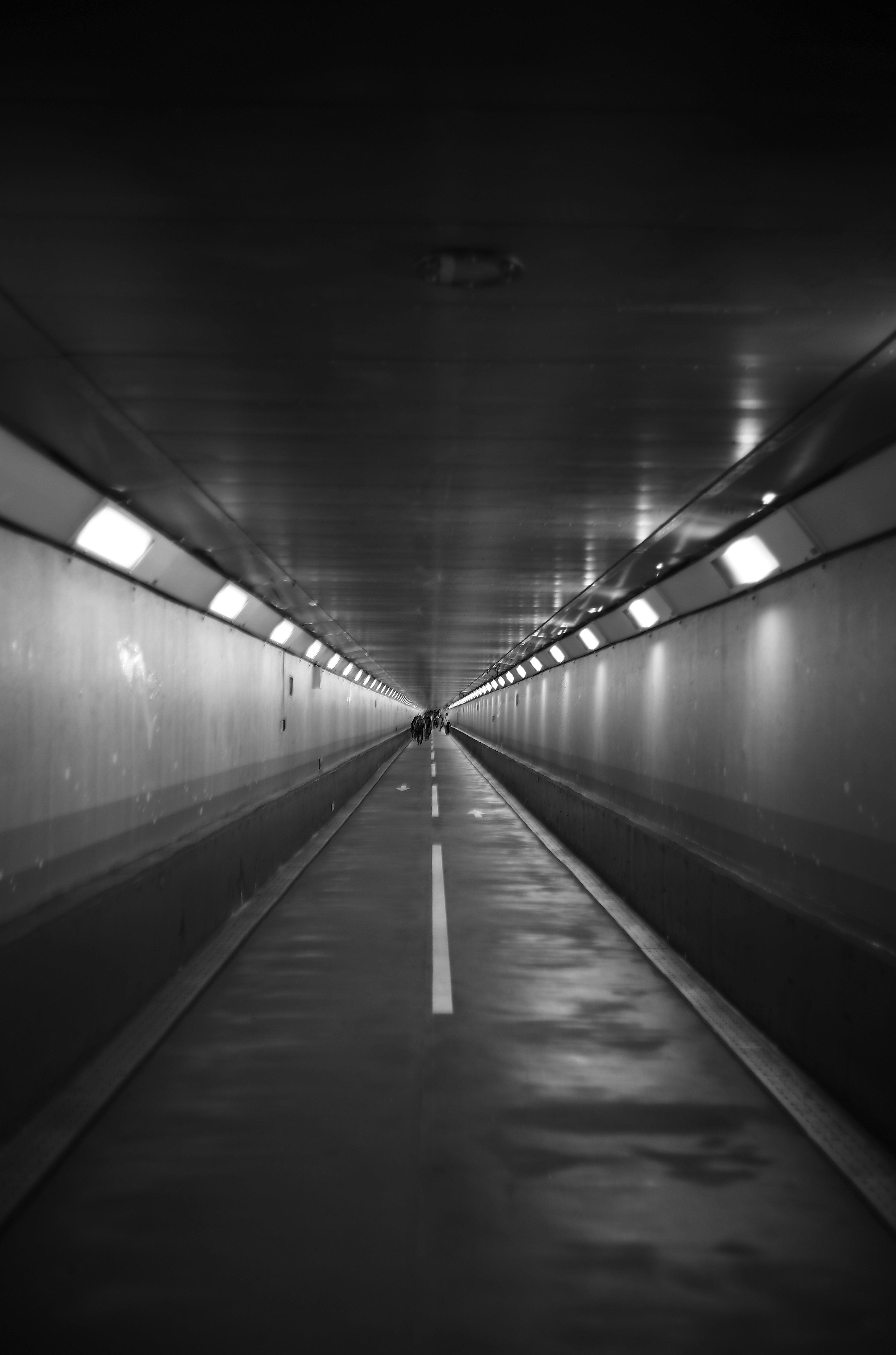 Dunkler Tunnel mit geradem Weg und Deckenlichtern