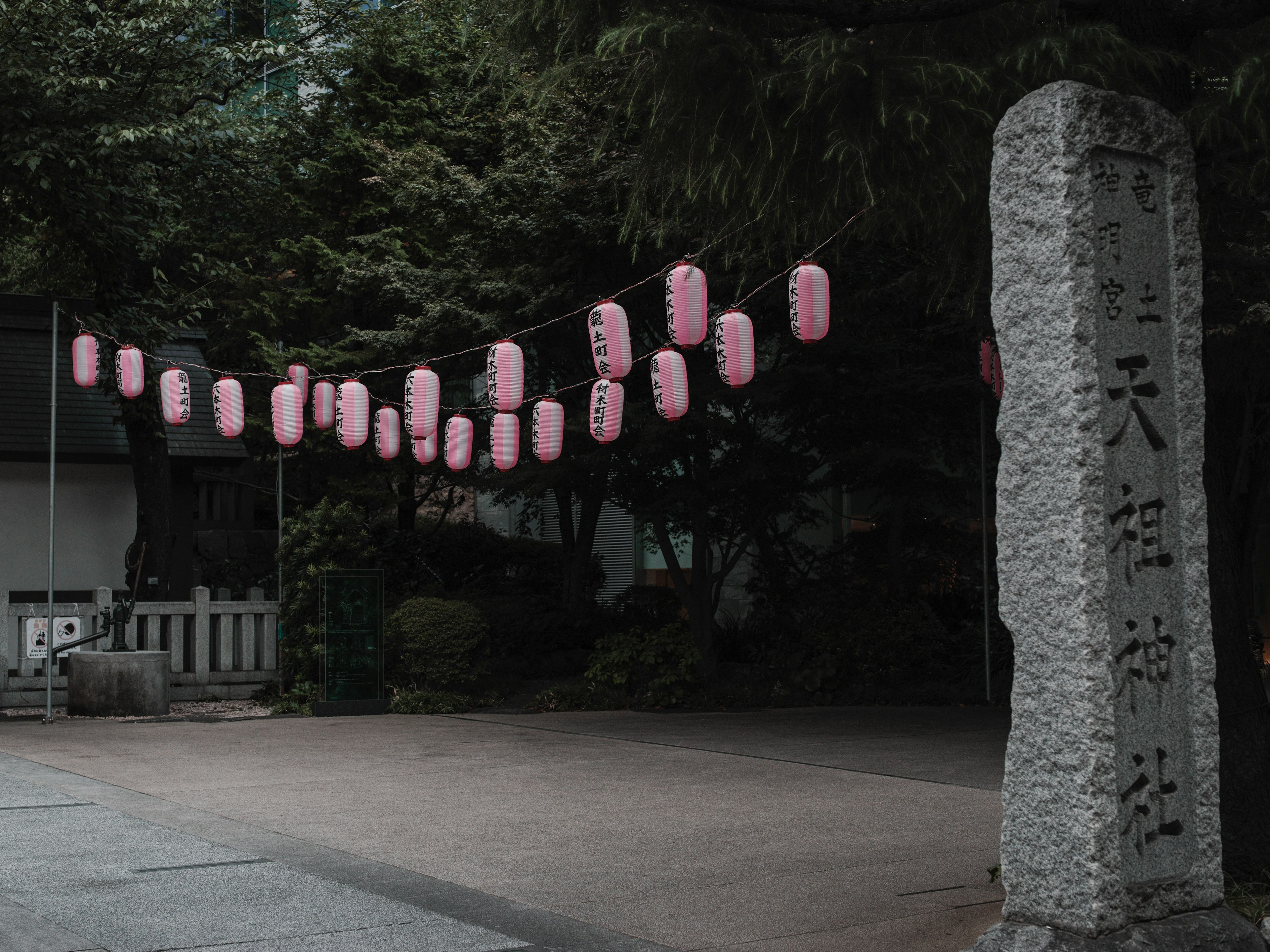 石碑と提灯が並ぶ静かな神社の入口