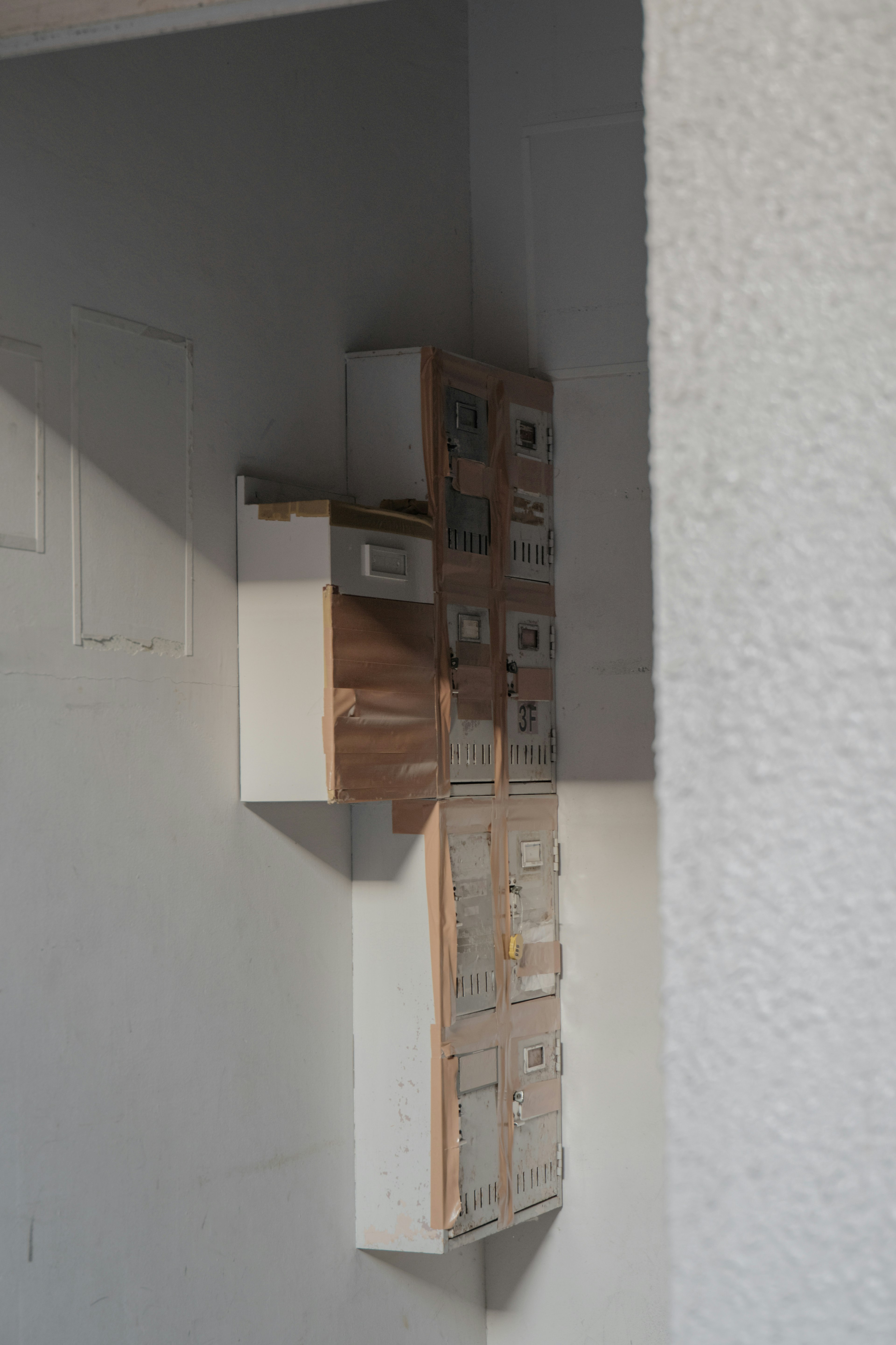 Wooden storage unit with small boxes mounted in the corner of a white wall