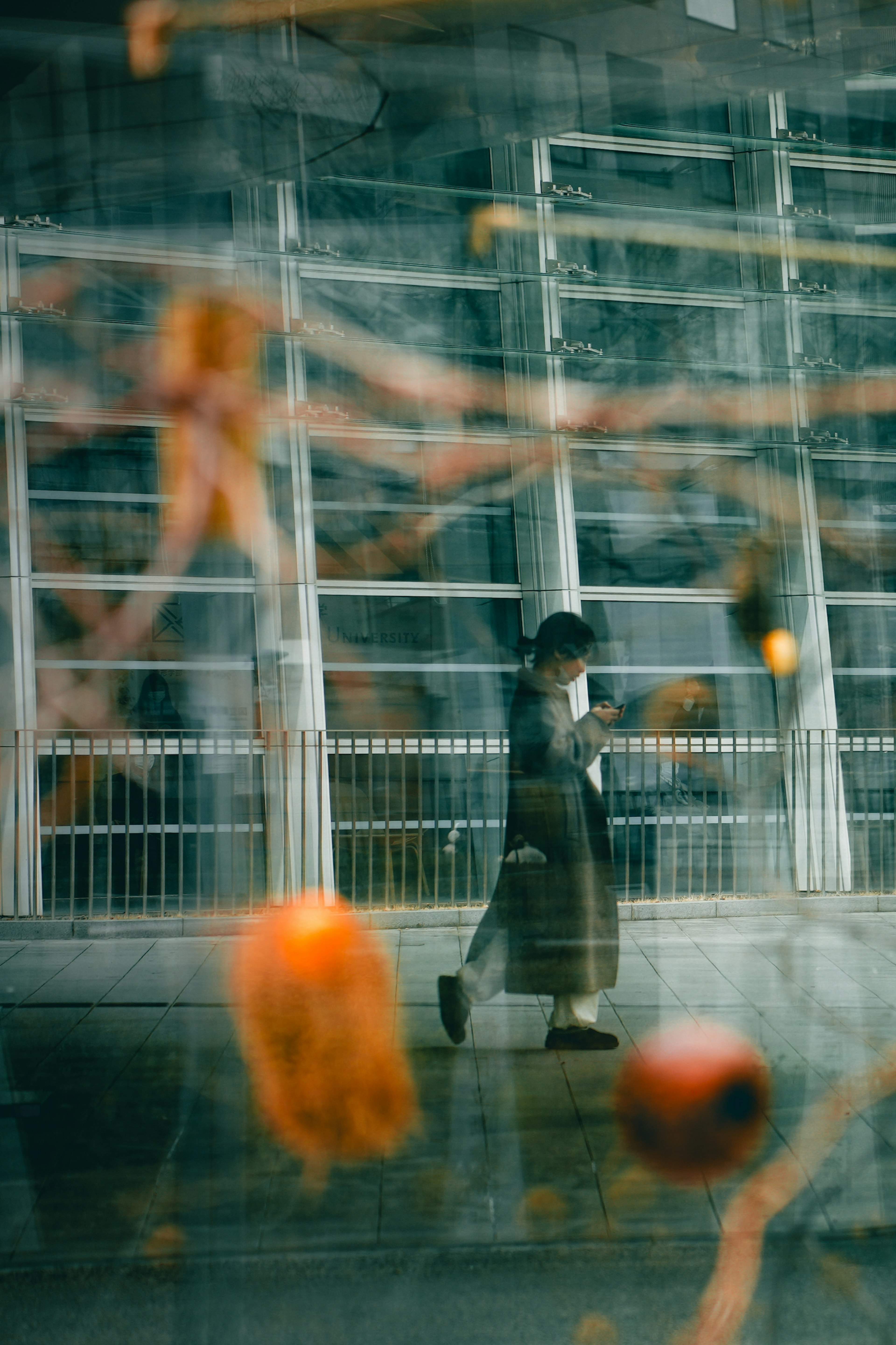 A figure walking past orange objects in a blue background