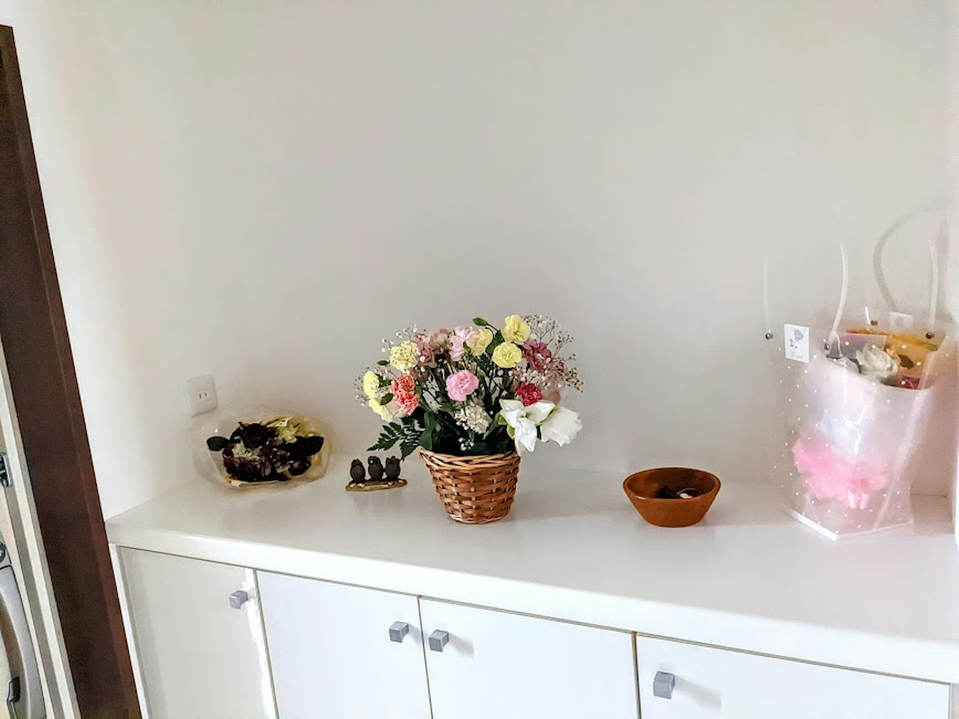 A simple shelf with a flower basket and decorative items