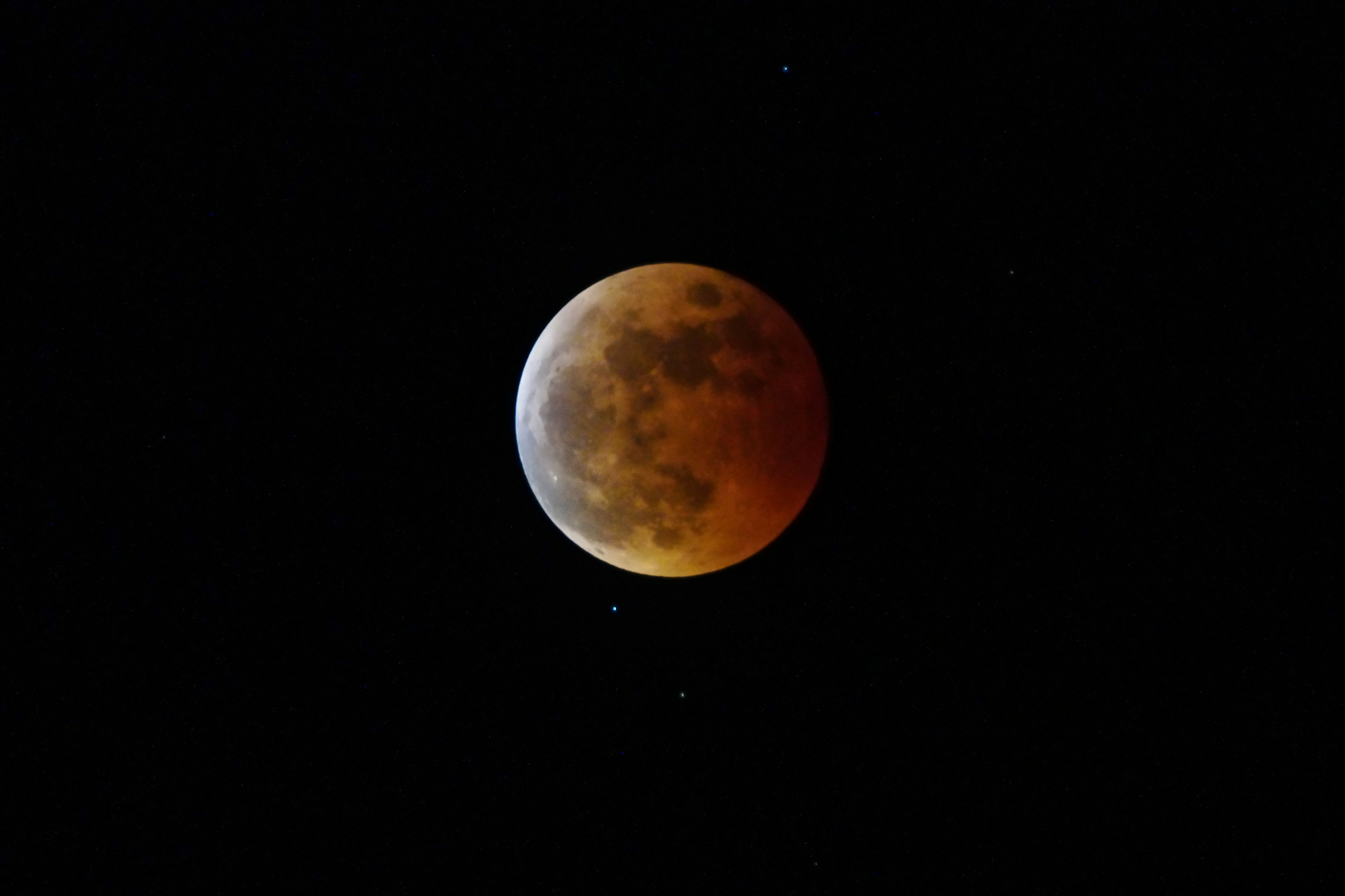 Luna rossa con stelle visibili nel cielo notturno