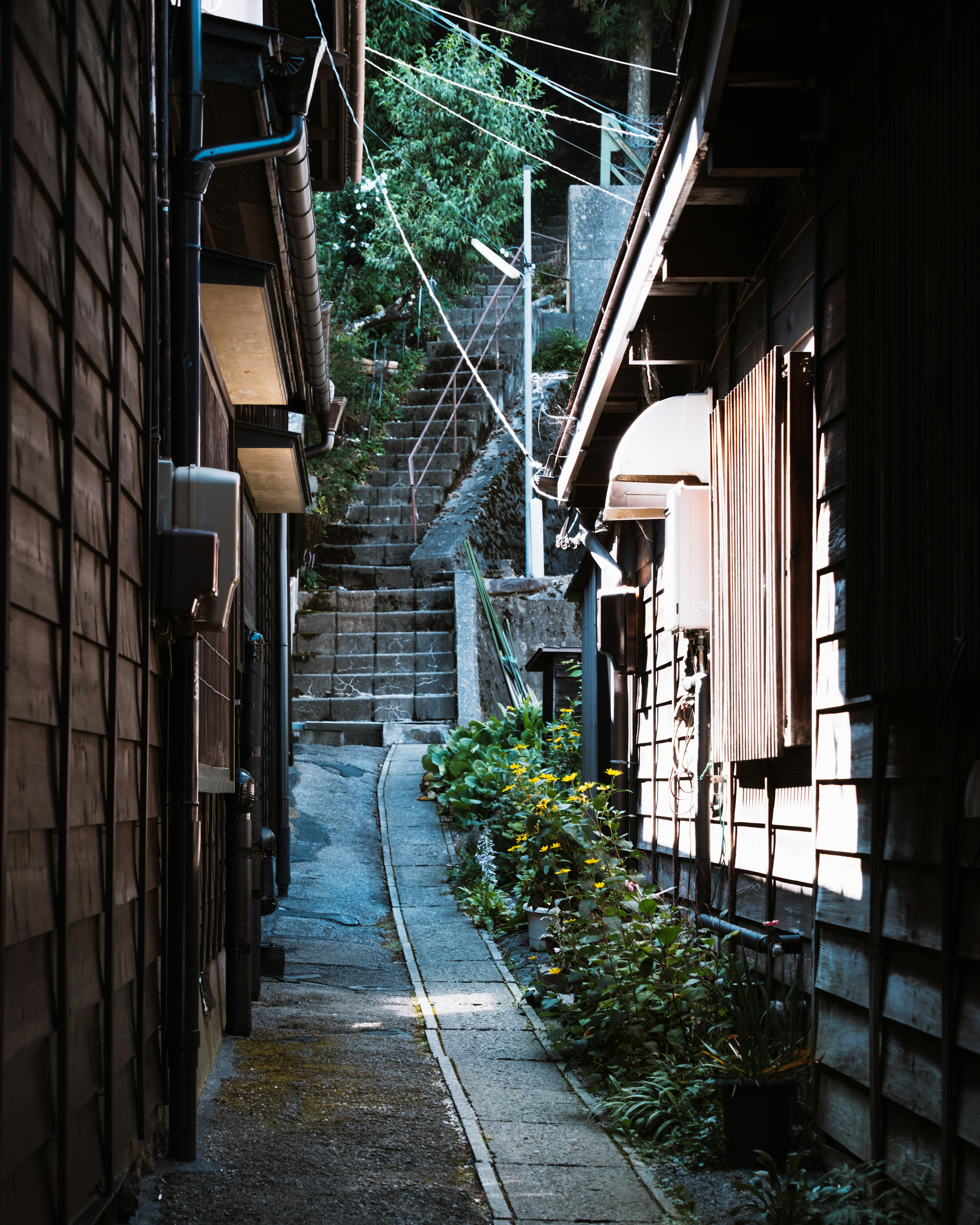 狭い路地と階段の風景周囲には木造の家々が並ぶ