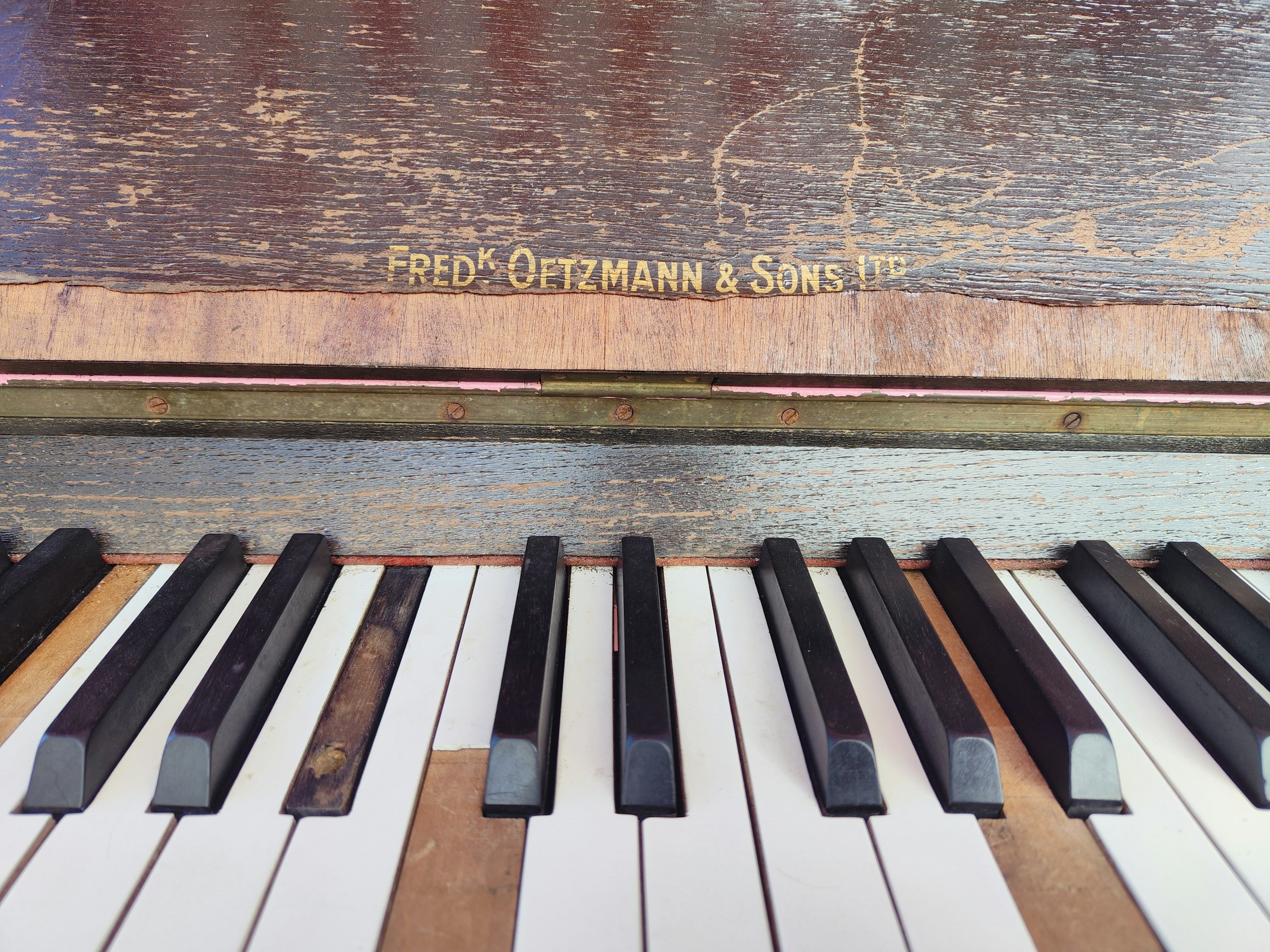 Close-up dari kunci piano vintage dengan nama produsen