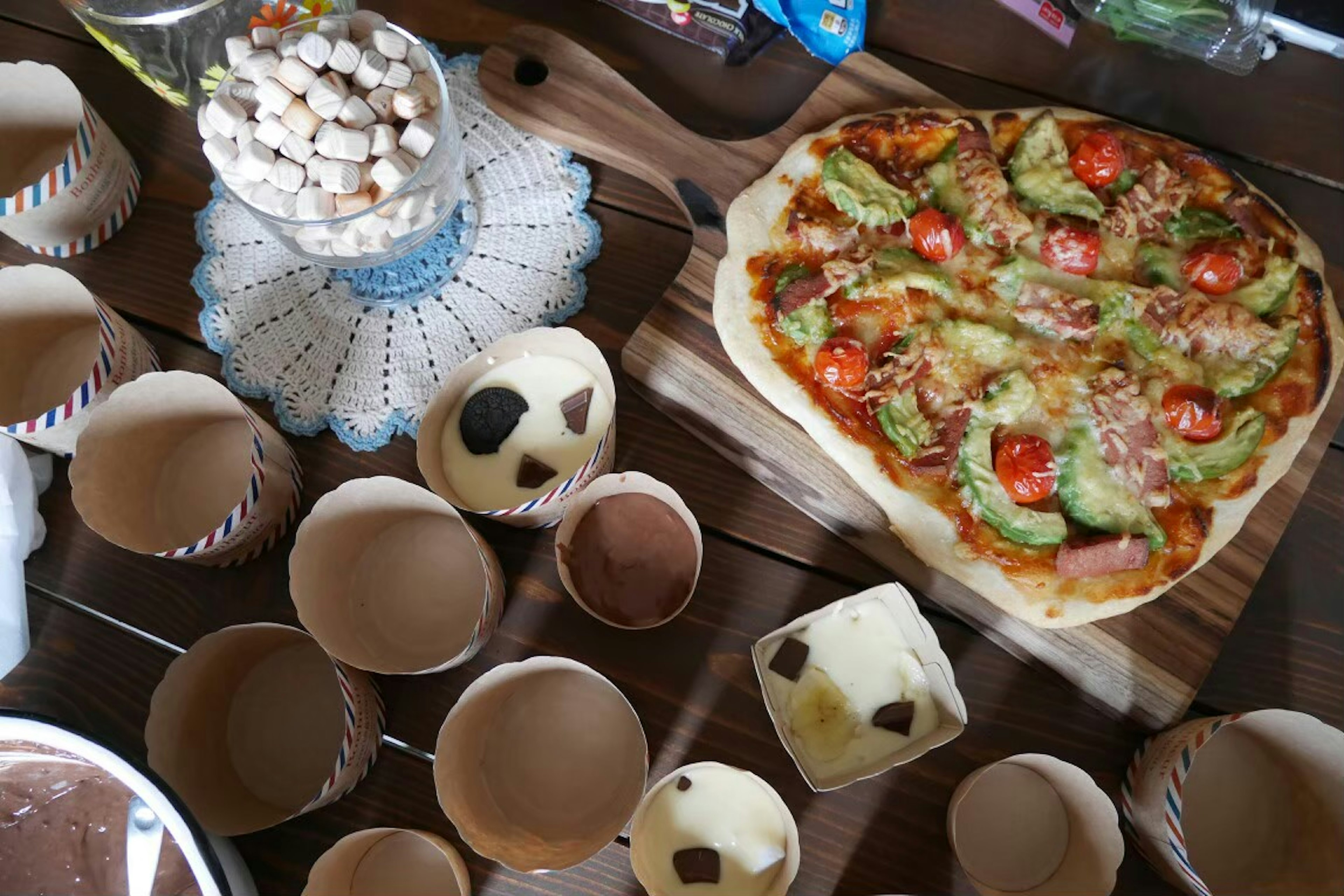 A table featuring a pizza and various desserts