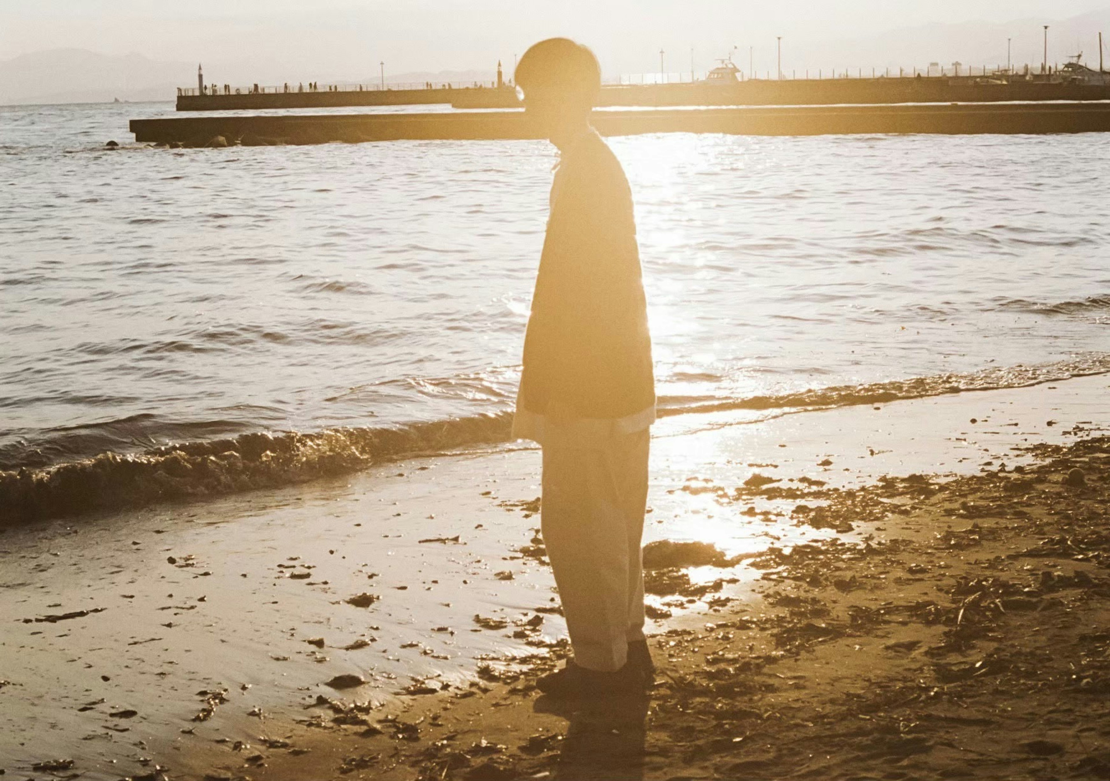 Silhouette d'une personne sur la plage au coucher du soleil