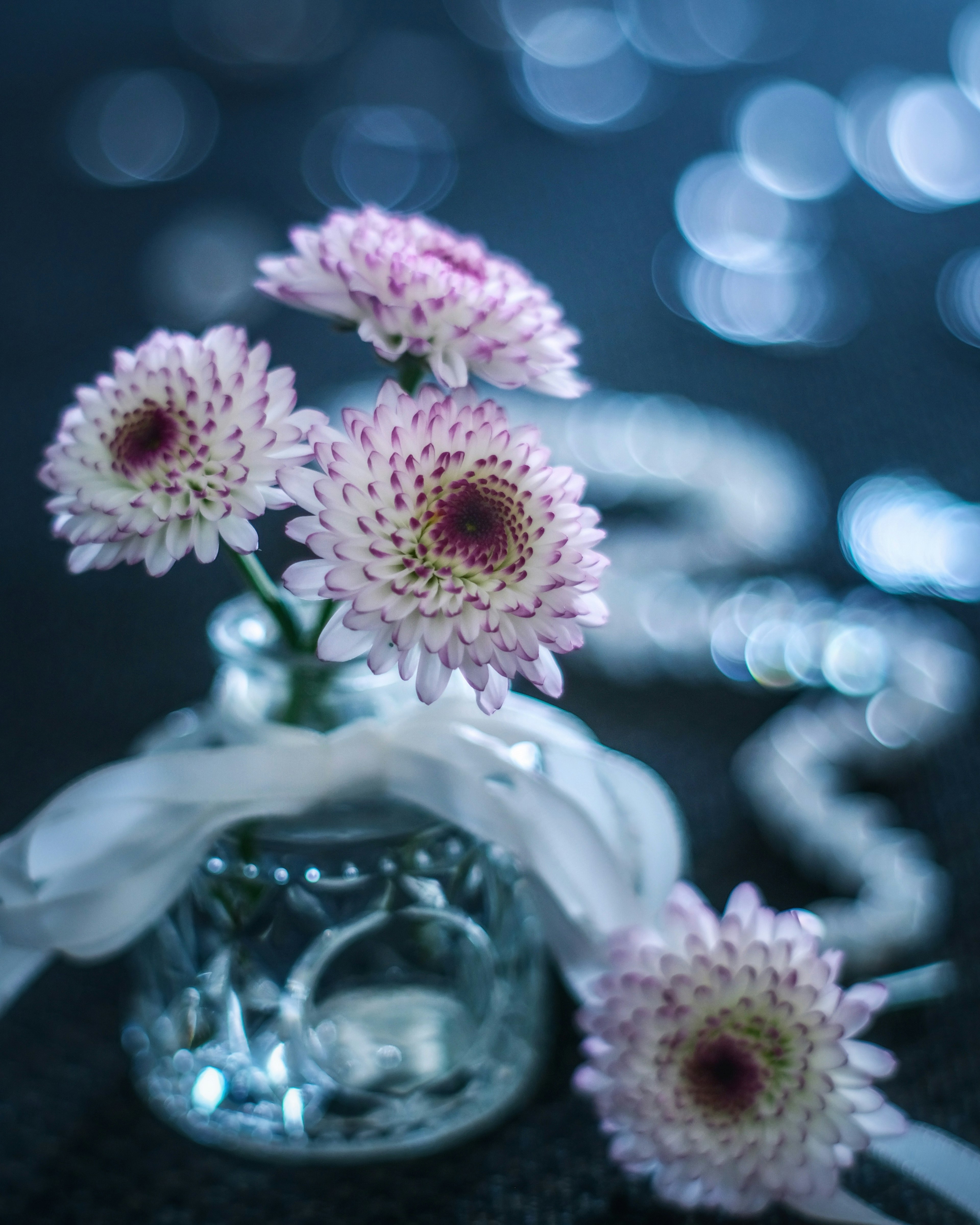 Pequeño frasco de vidrio con flores rosas y decoración de cinta